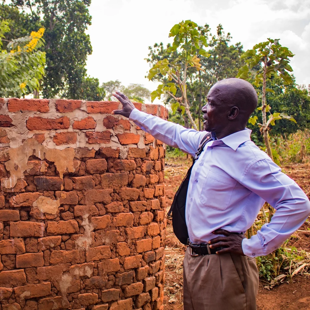 Martin demonstrates how a shower reinforced with a layer of cement at the top does not succumb to erosion. This shower will serve its users for many years to come with minimal to no repairs.