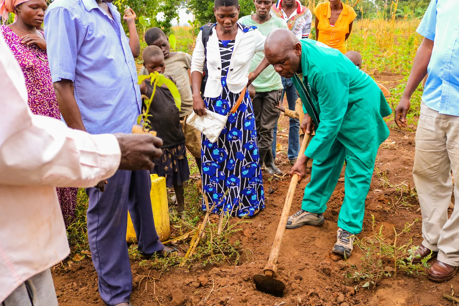 With the holes for their saplings prepared, the community gathered around to watch Alex and Abraham plant the first tree in their village.