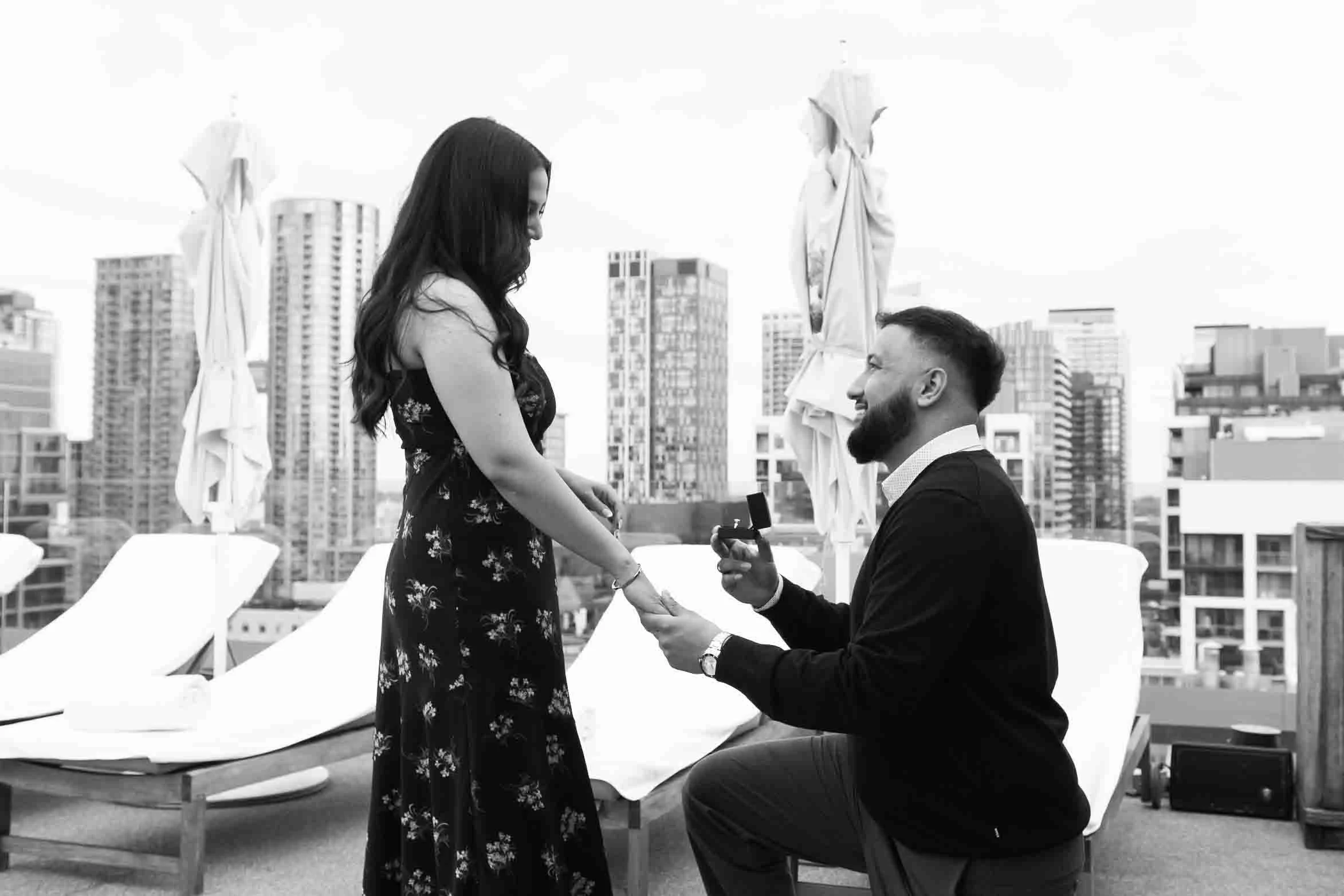 black and white photo of a surprise proposal photography in downtown toronto at harriet's rooftop.