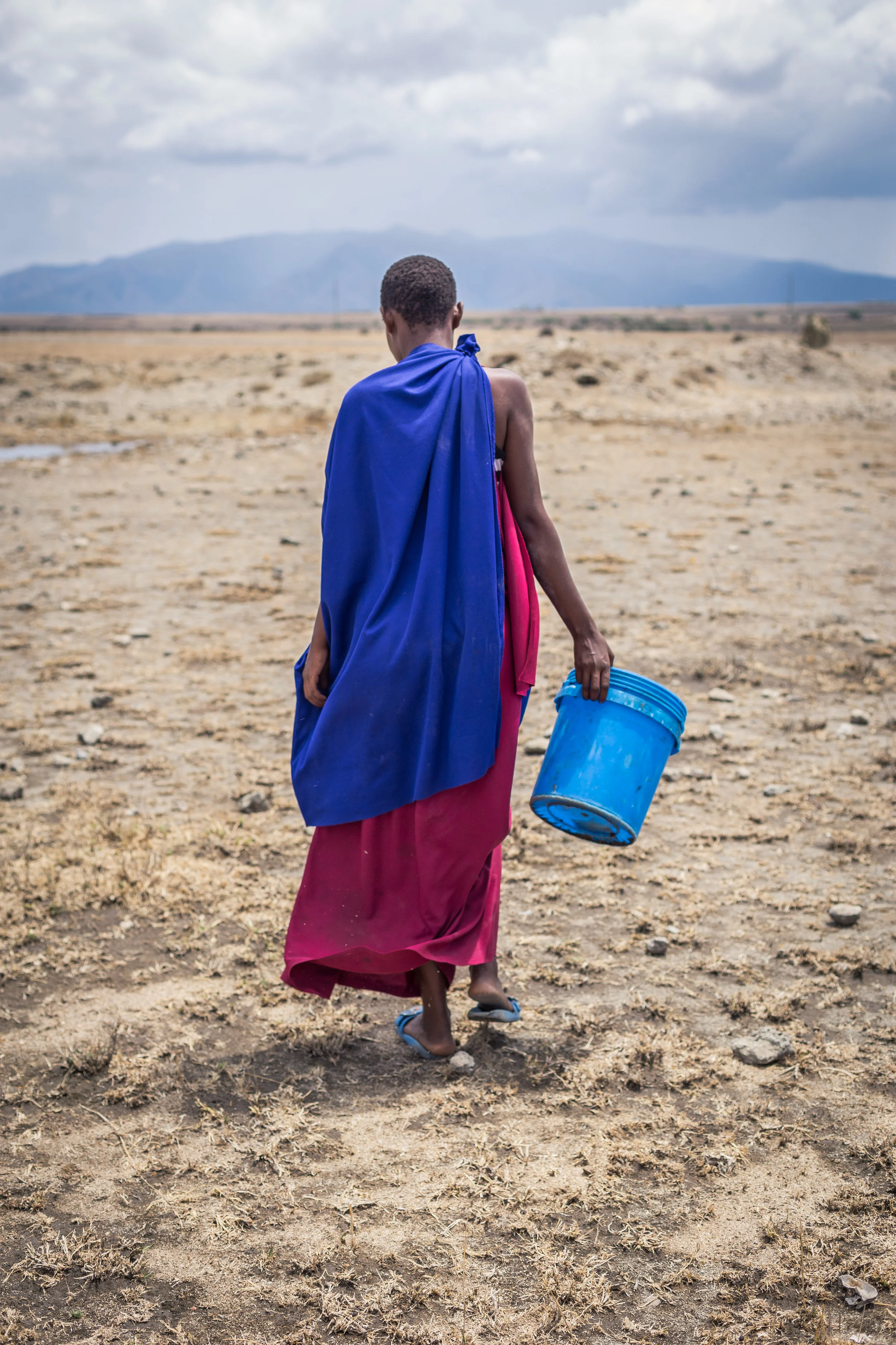 Anna walking to get some water outside her home. 