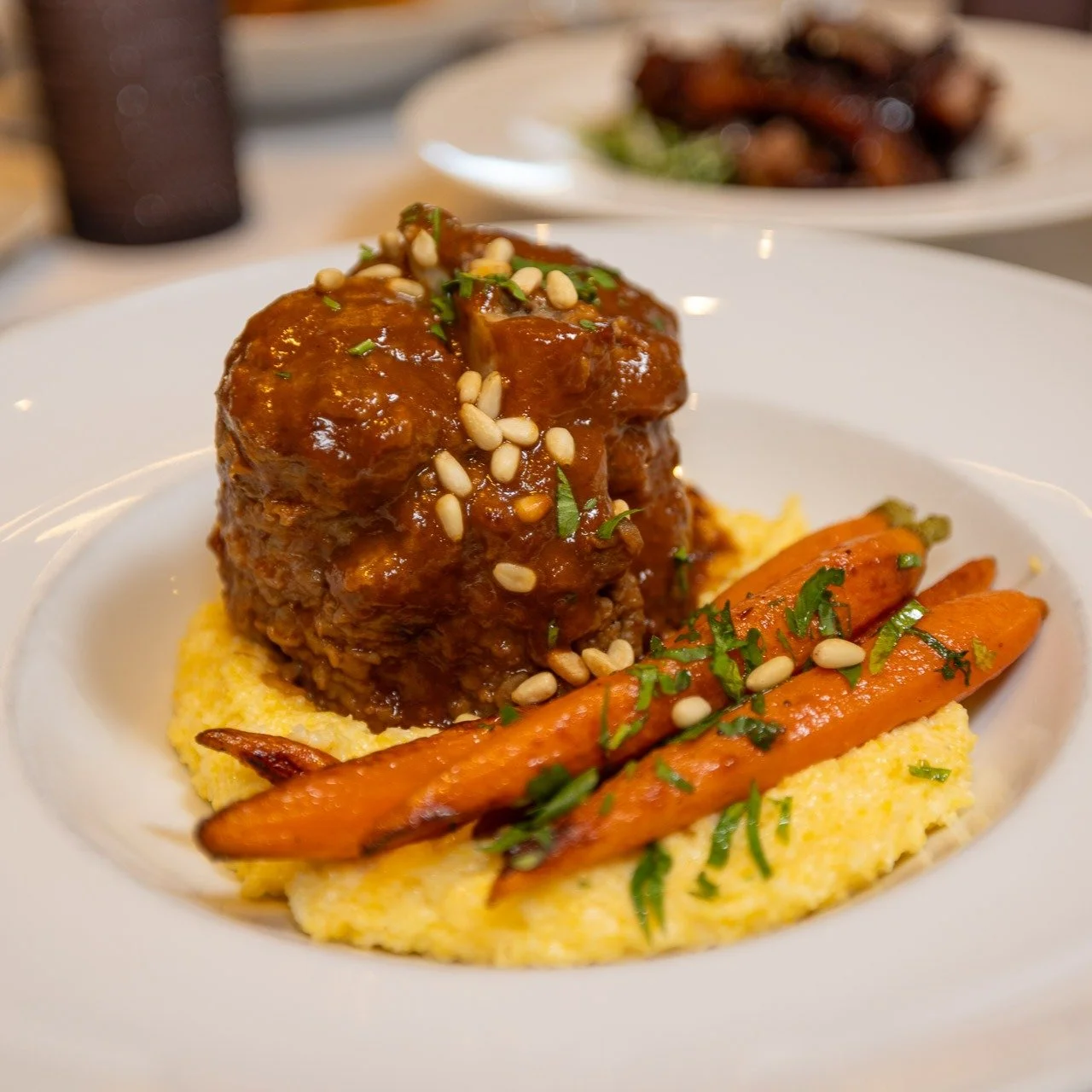 Our Pork Osso Buco is a favorite among our regular patrons. Made with slow-braised Niman Ranch heritage pork shank with heirloom carrots, creamy polenta, and red wine jus ∙ finished with pine nut gremolata. No knife needed. #parkcityrestaurants #park