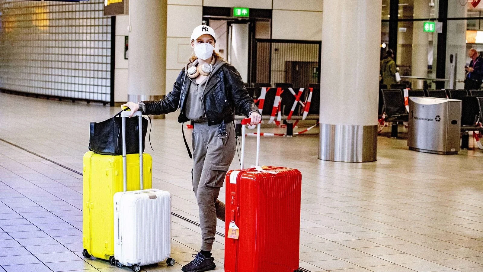 Una pasajera camina por el aeropuerto Schiphol de Amsterdam el 13 de mayo de 2020. La aerolínea KLM Royal Dutch Airlines, como la mayoría de las compañías aéreas, exigen que los pasajeros se cubran el rostro para subir a los aviones.