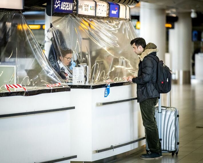 Una cortina de plástico cubre el mostrador de una aerolínea en el aeropuerto Schiphol de Amsterdam el 27 de marzo de 2020. Se han implementado este tipo de barreras entre trabajadores y viajeros para evitar la propagación de la COVID-19.