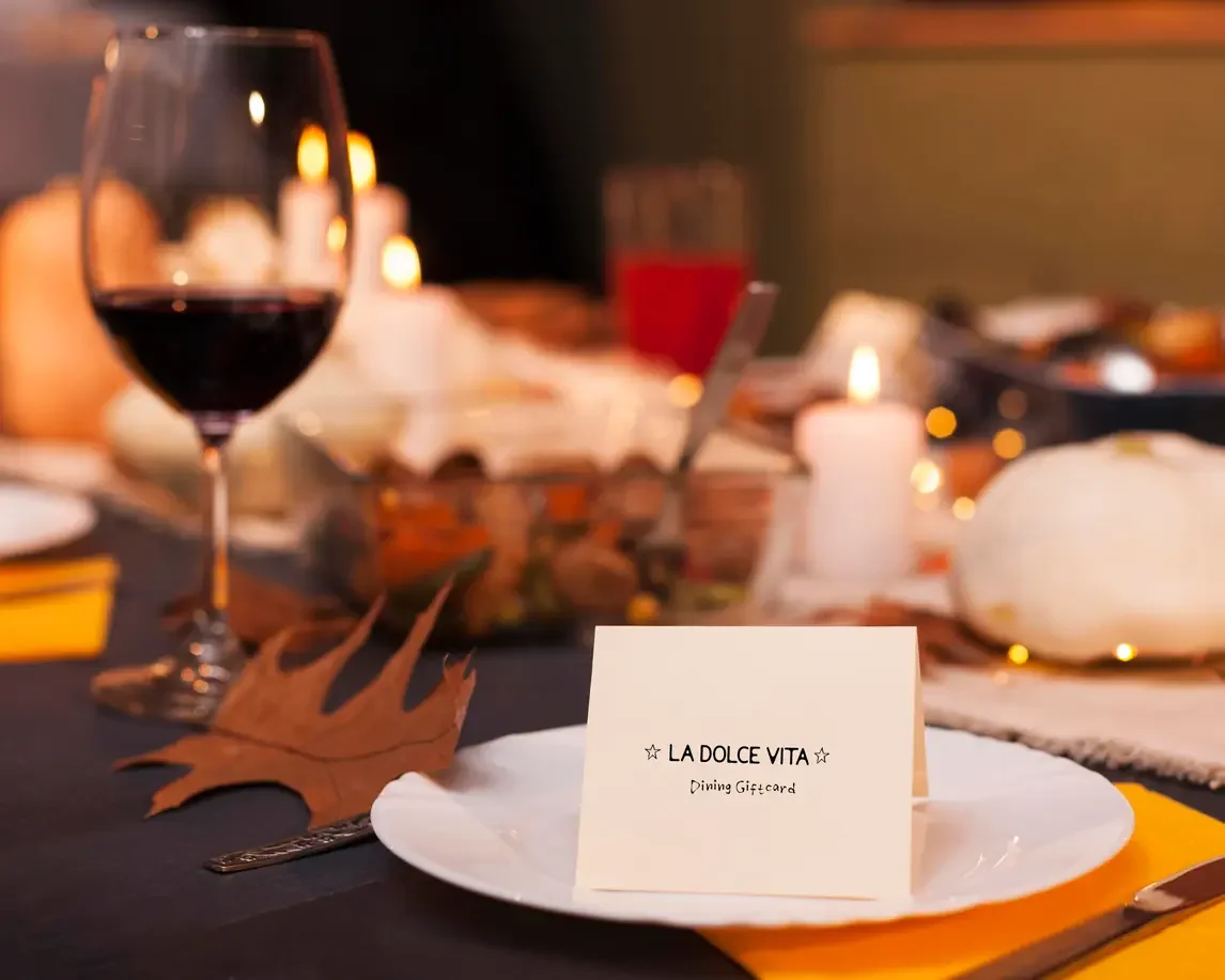 Dining table setting with a La Dolce Vita gift card, representing in-restaurant dining and gift card use in Ottawa.