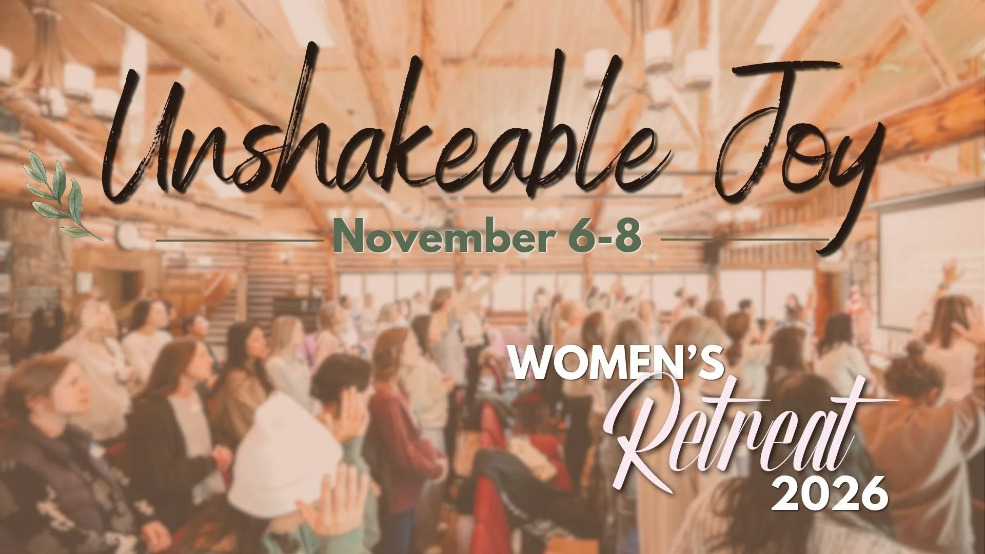 A large group of women attending a conference or event in a spacious, wooden-ceiling hall with some women raising their hands. Overlaid text advertises the 'Unbreakable Joy' women's retreat from November 6-8, 2026.