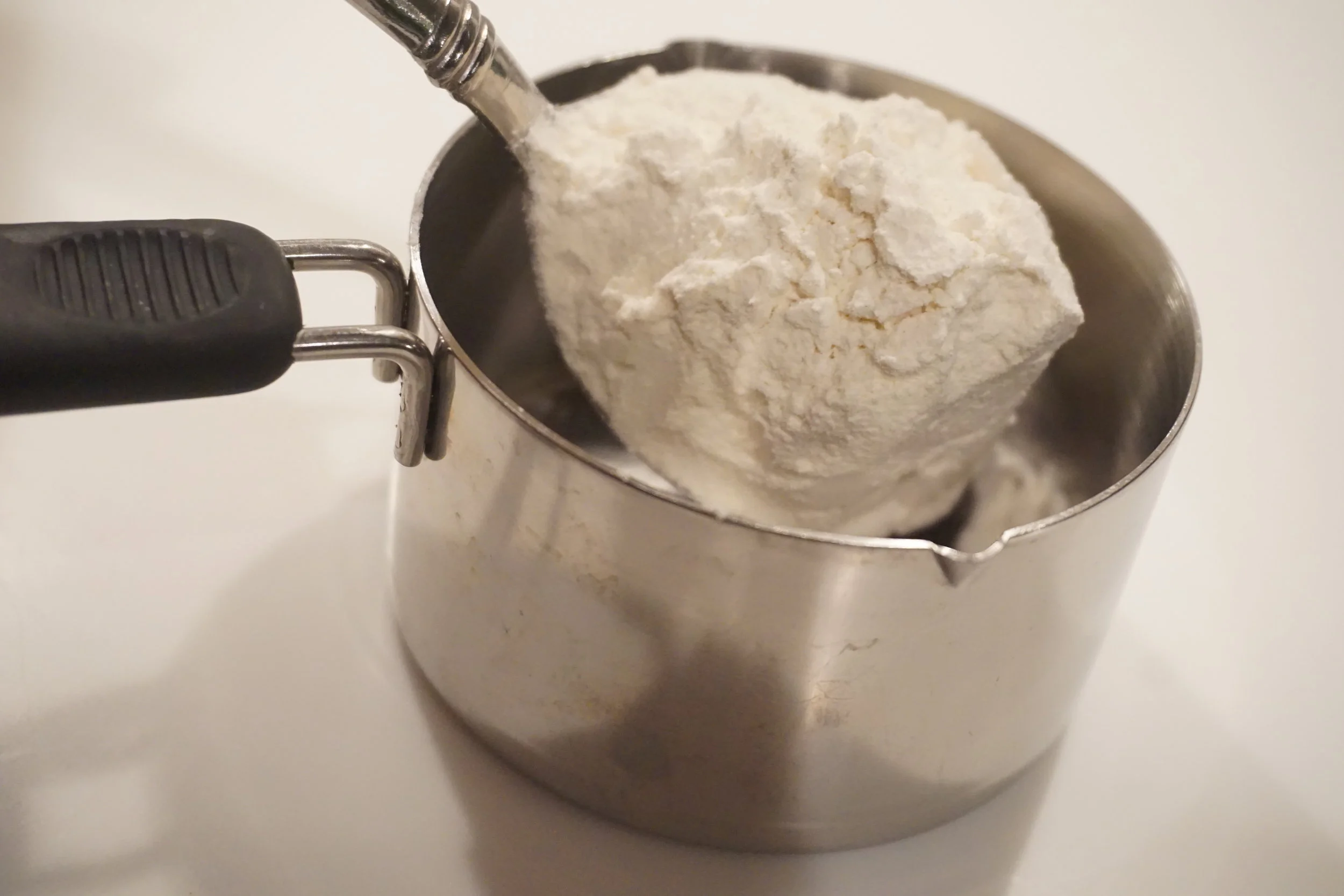 Spoon ingredient into cup