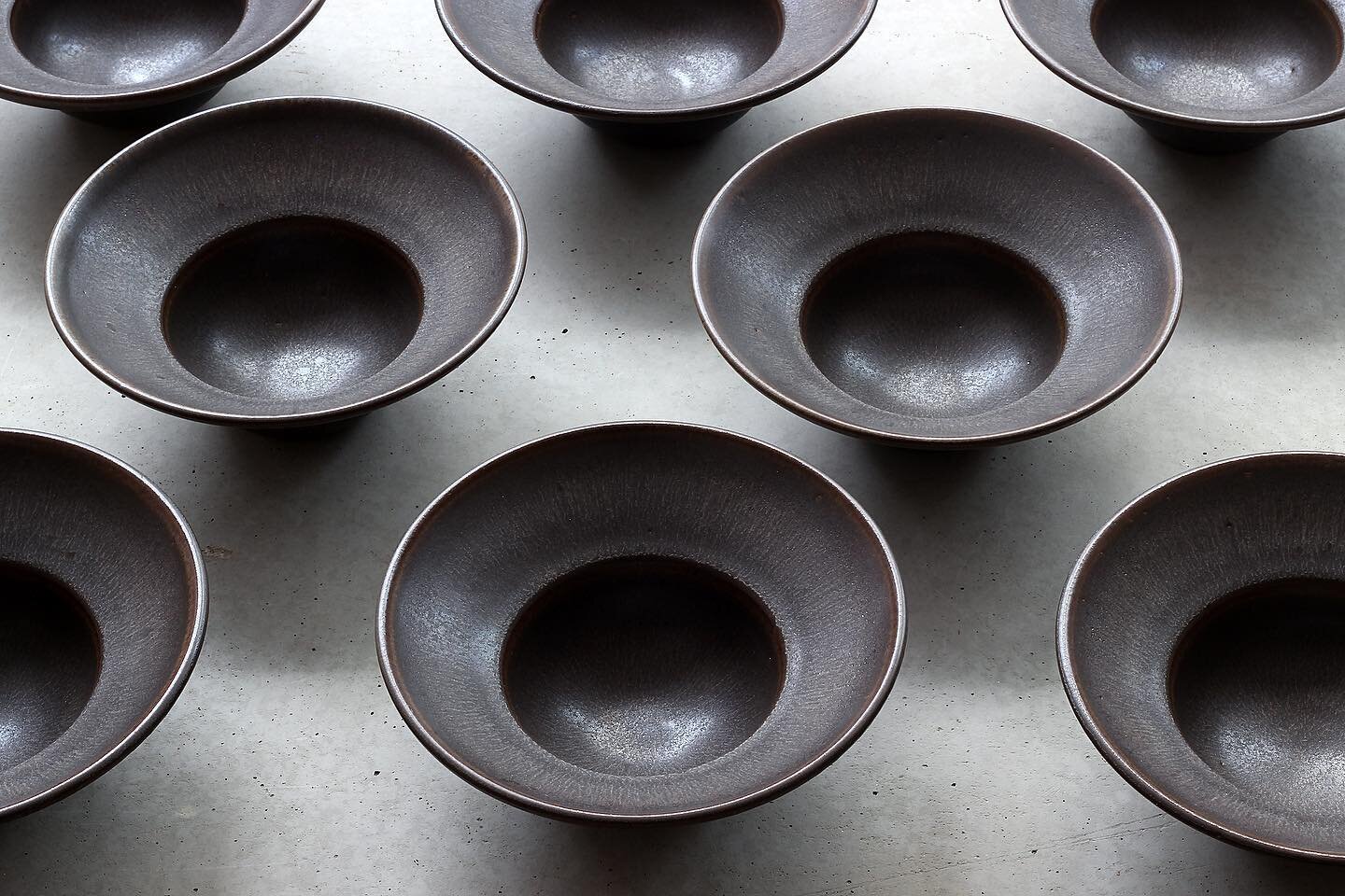 Dark brown plates with a large rim.
After throwing so many of these in the last months in various sizes, this is the last batch before next spring tableware orders 🌱