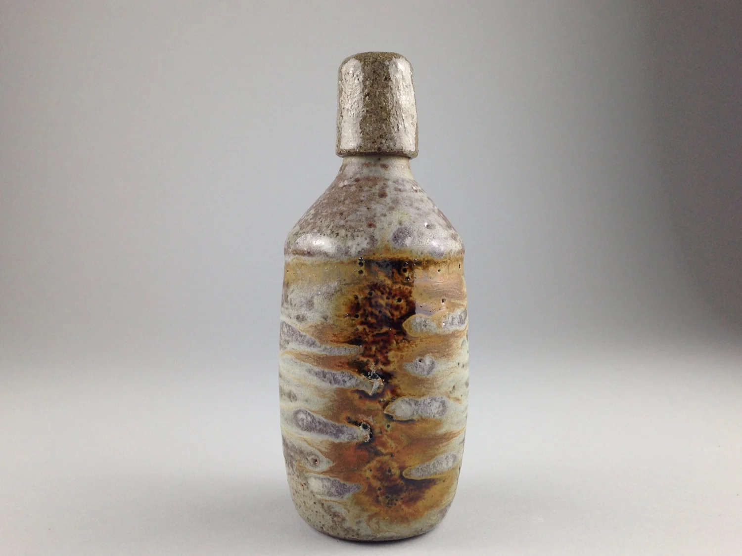 Capped stoneware bottle, soda fired