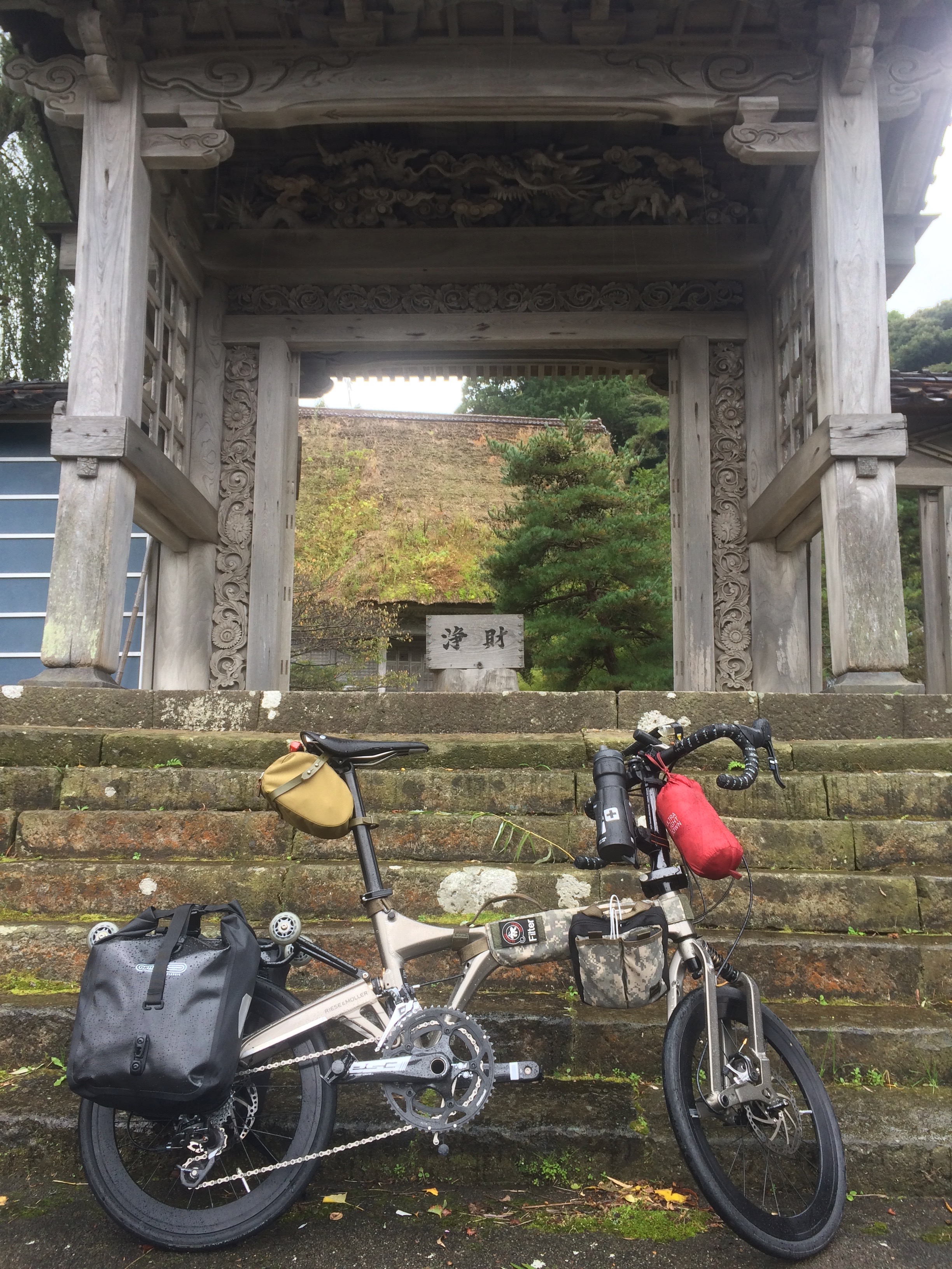 Parking in front of the old wooden temple gates.