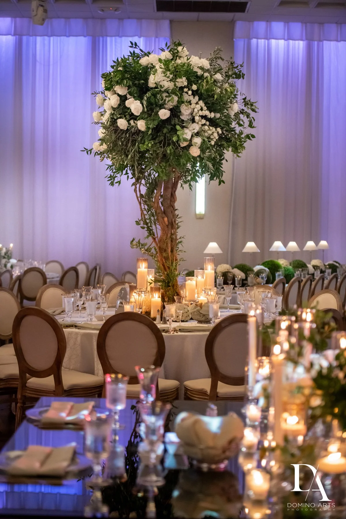 Romantic wedding reception décor with candles and florals at Emanuel Luxury Venue in Miami Beach.