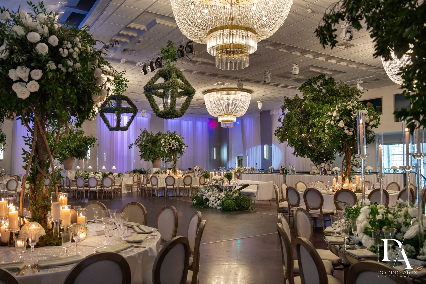 Garden-inspired wedding décor with lush greenery and florals inside the grand ballroom at Emanuel Luxury Venue in Miami Beach.