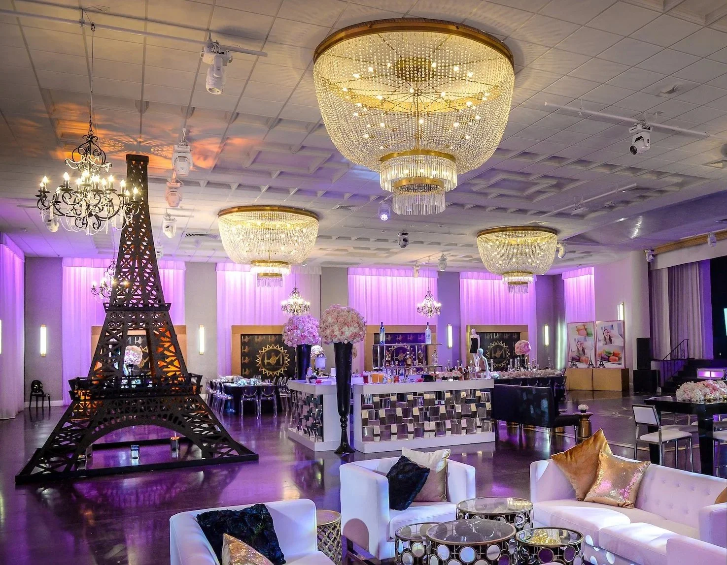 Bat Mitzvah celebration setup at a Miami Beach event venue featuring Paris-inspired decor, chandelier lighting, lounge seating and custom bar design