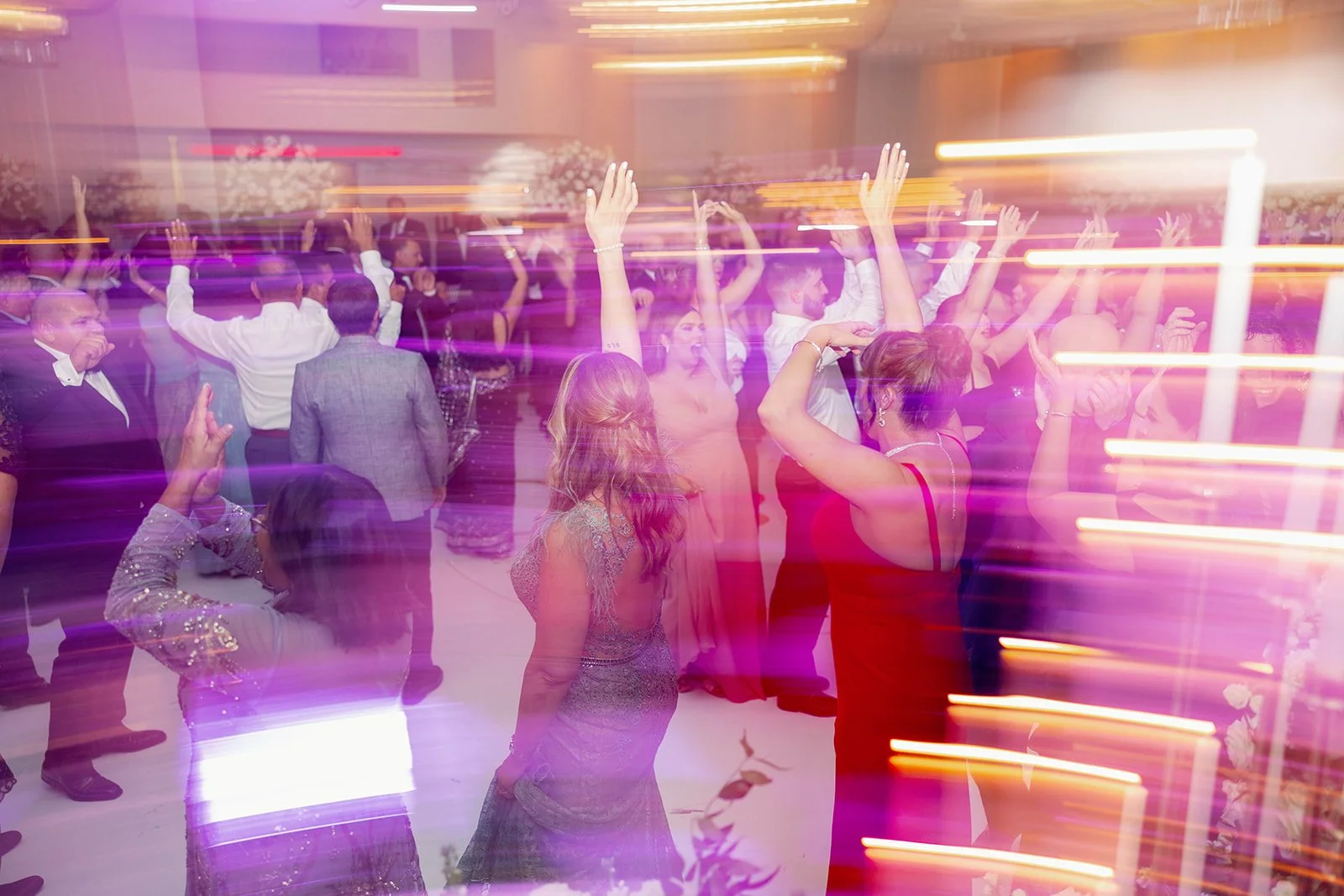 Family and friends dancing together during a joyful Miami wedding reception.