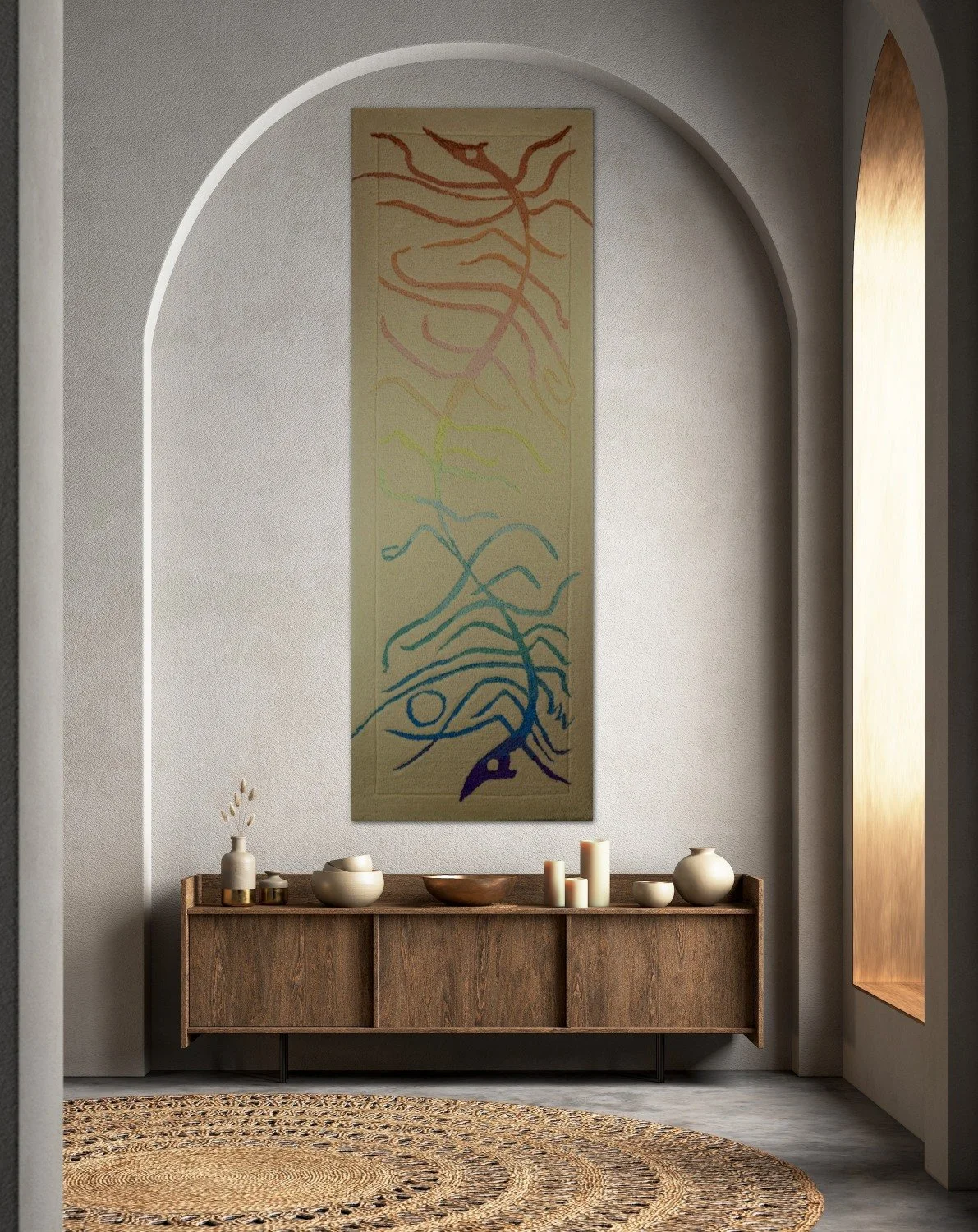 Interior with a wooden console table decorated with vases and candles, a hand tufted rug, abstract art hanging on a light-colored wall, and a tall narrow window with warm light.
