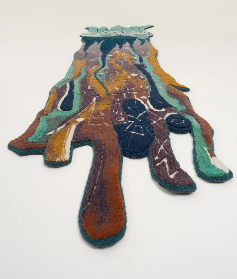 Colorful organic shaped rug, like a horse, with abstract patterns, placed on a plain white background.