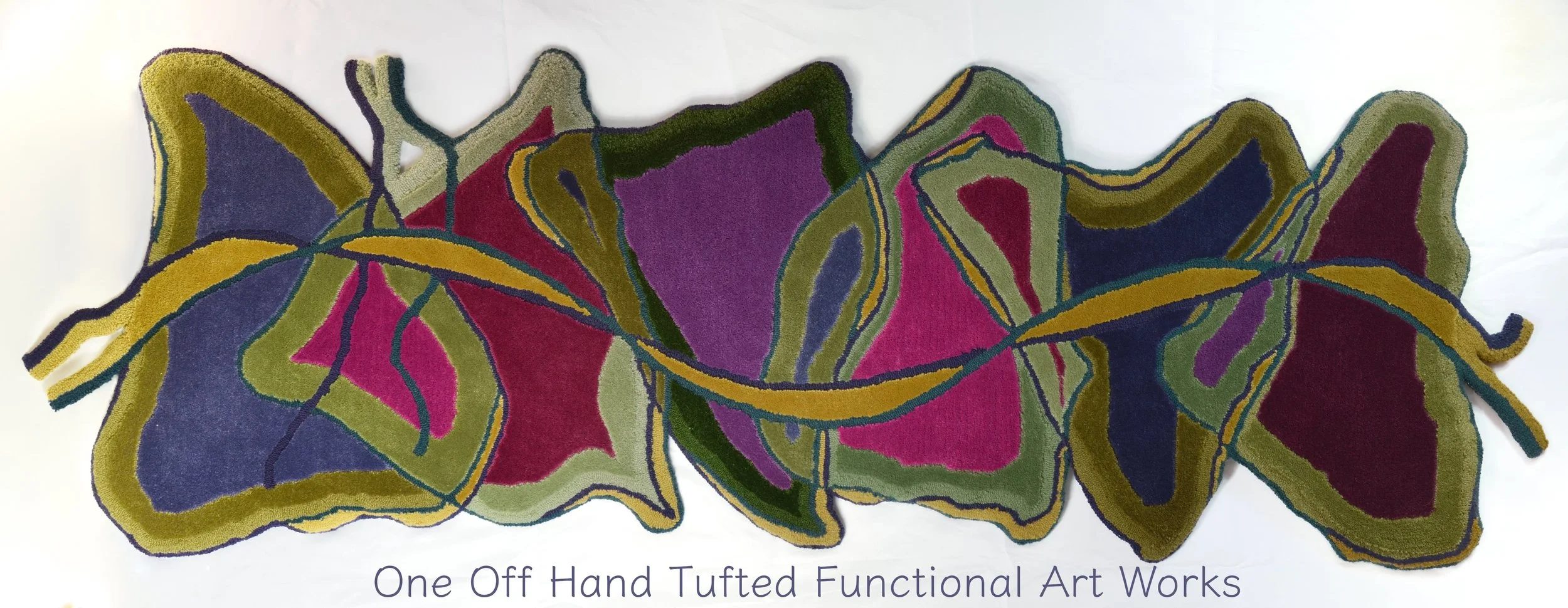 spring colours hand tufted runner displayed lengthwise the design having irregular edges of the six joined trianges with a ribbon running through the length