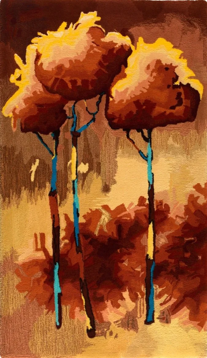 Abstract hand made wool pile hearth rug of three trees with blue trunks and brown and yellow foliage.