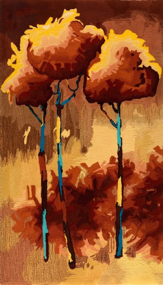 Abstract hand crafted wool pile textile of three trees with brown canopies and blue trunks against a warm-colored background.