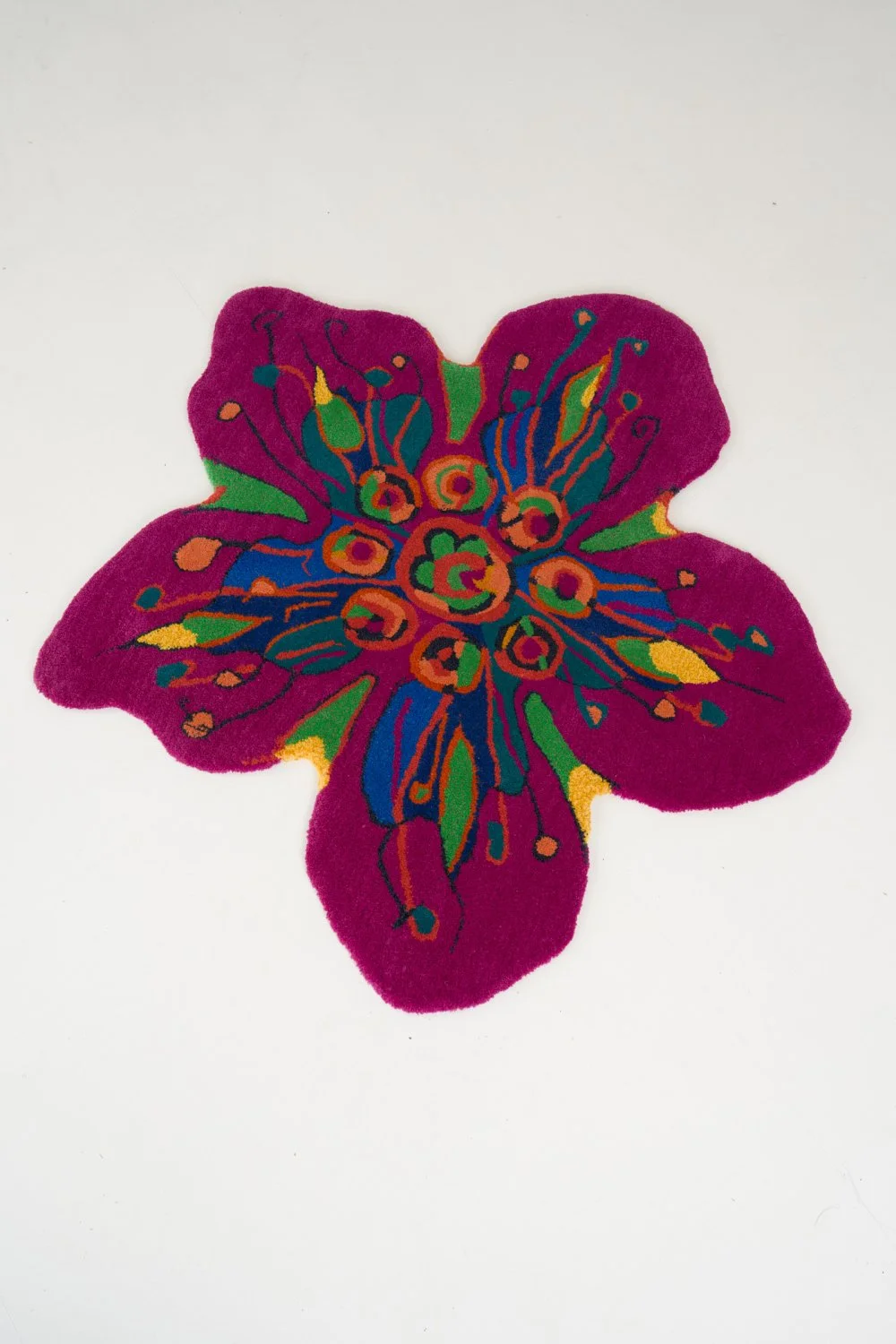 Colorful butterfly-shaped rug with vibrant patterns on a white background.