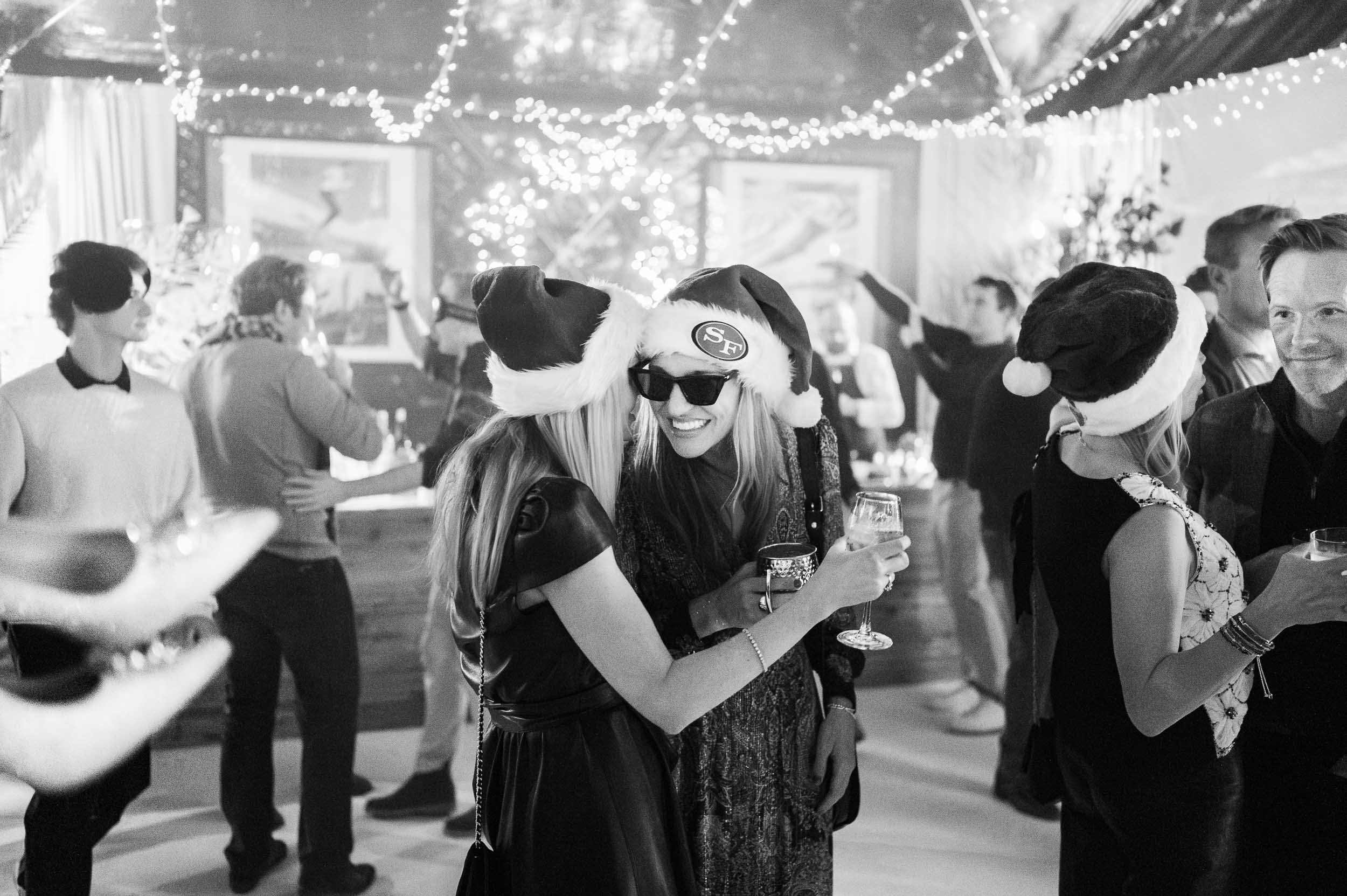 People wearing Santa hats and Christmas decorations at a holiday party.