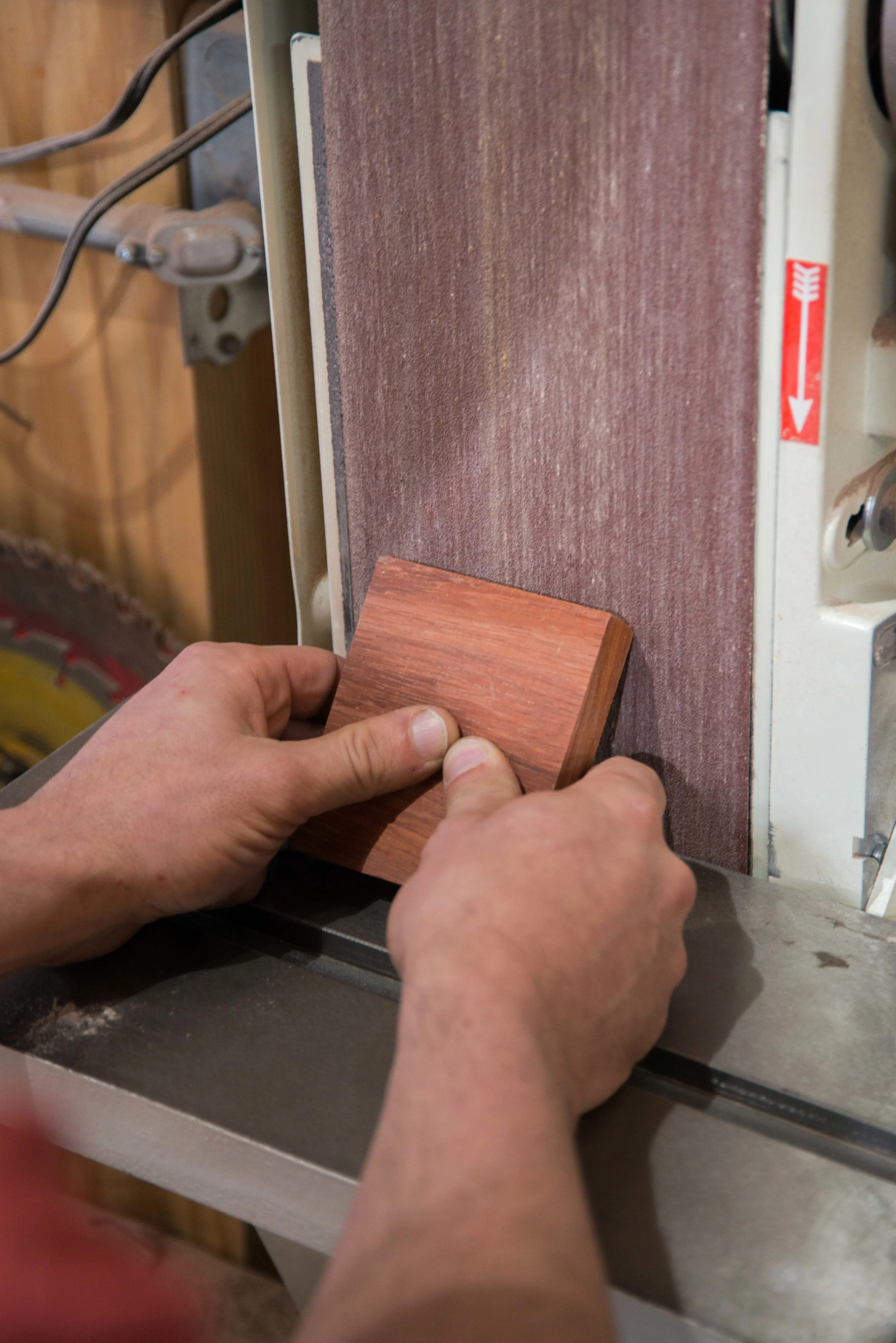Splintered material or hand if the belt grabs onto the material and pulls it flat against the table.
