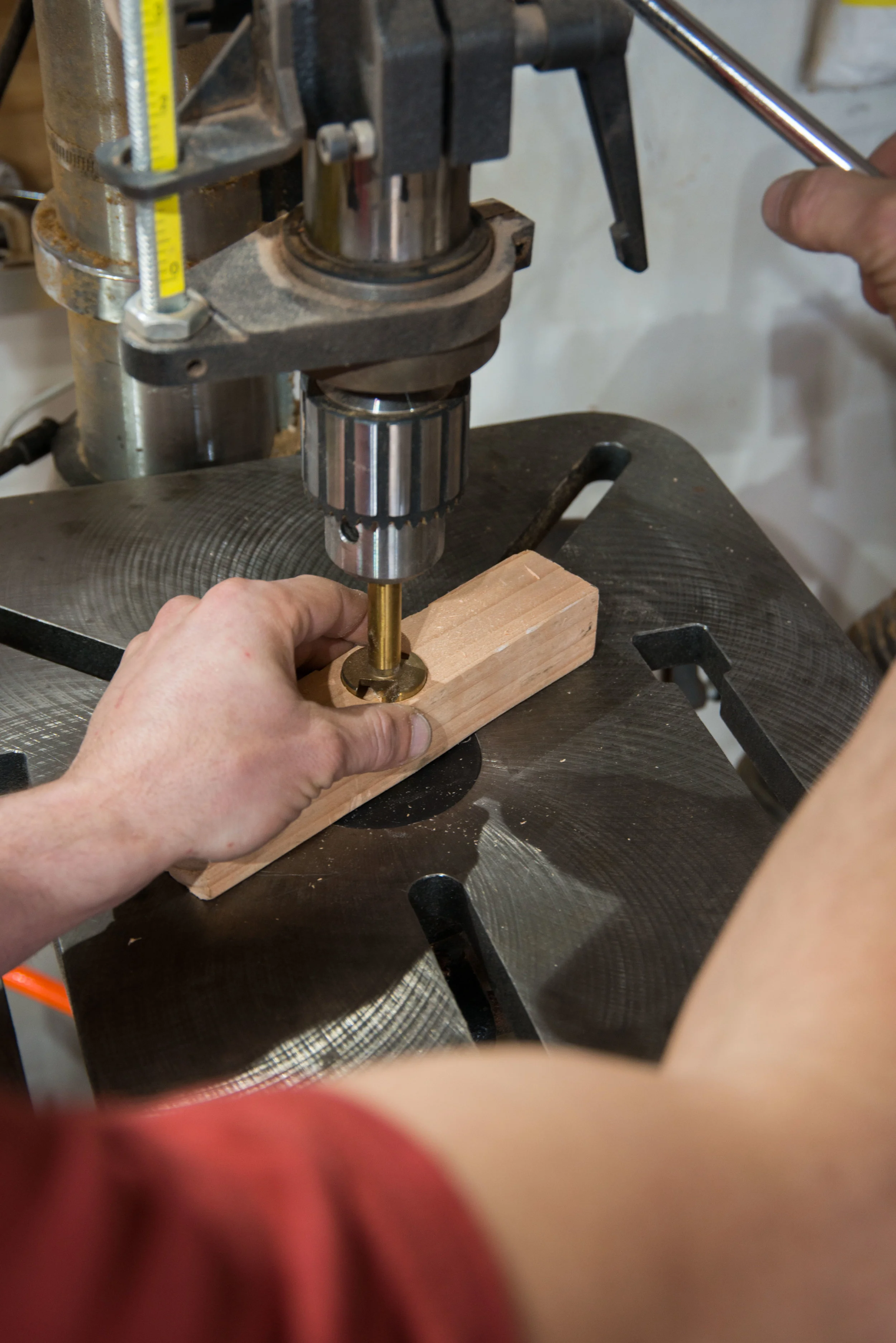 When this piece starts spinning - as its almost certain to do with this large Forstner bit - if I don’t release it quickly enough, it will wrap my hand around the shaft. And avoid any temptation to increase your holding power by anchoring your finger through those holes in the drill press table: that will be even harder to quickly pull out of when the piece turns, shearing your finger off in the process. Ouch!