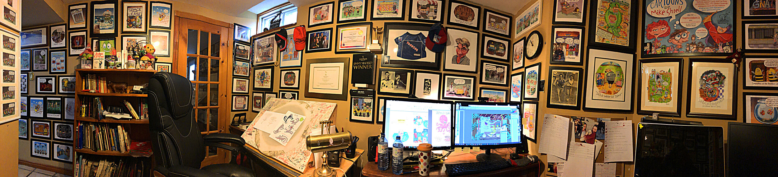Mike Shiell's office full of art, action and cartoons and awards and dogs.