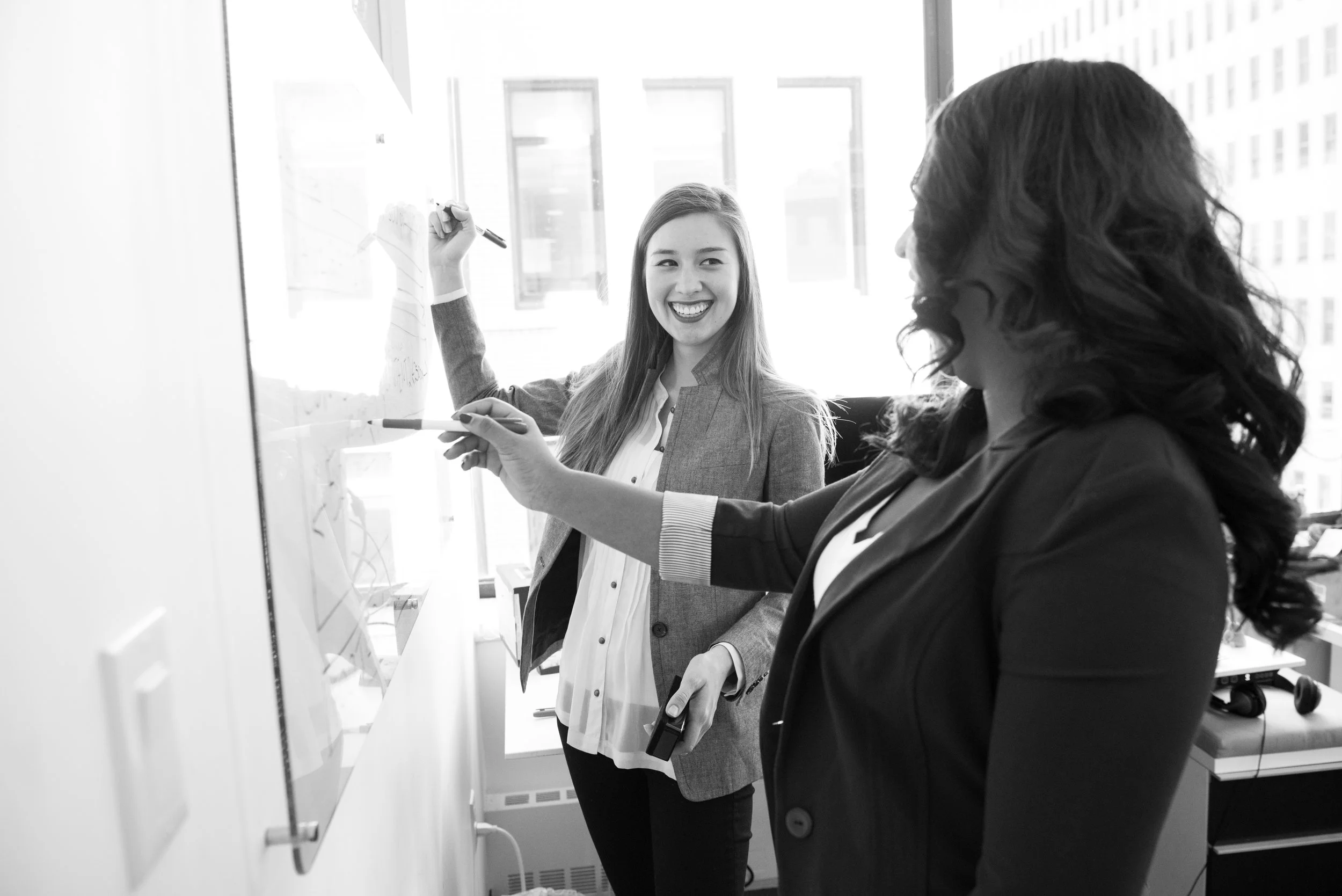 Canva - Two Smiling Woman Writing on Board.jpg