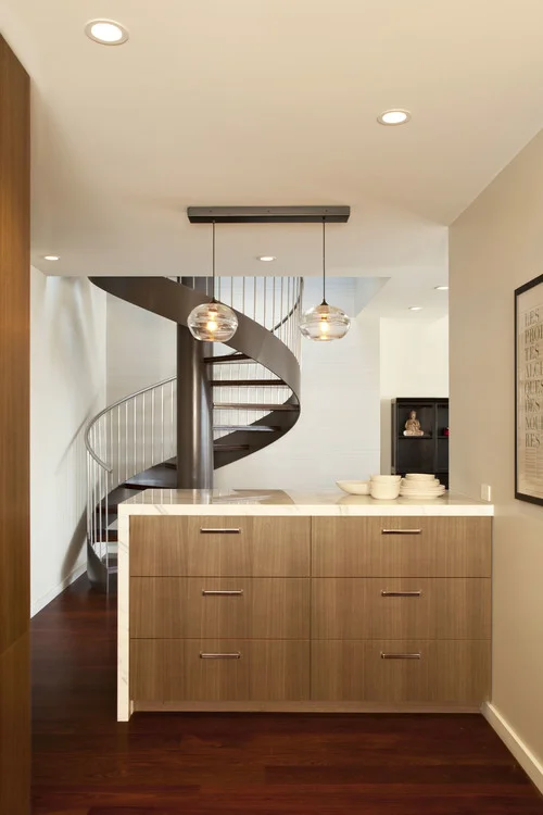 Kitchen renovation in a San Francisco Penthouse designed by Marin interior designer Studio SQUIRE featuring Wood Cabinets, Marble Waterfall Countertop, and Hand Blown Glass Fixtures