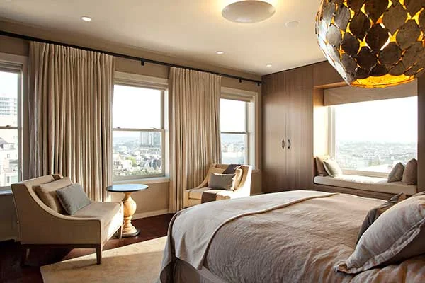 Modern Bedroom renovation in a San Francisco Penthouse designed by Marin interior designer Studio SQUIRE featuring a Window Seat, Wood Custom Casework, Accent Chairs, Gold Chandelier, and Area Rug