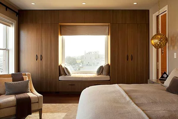 Modern Bedroom Renovation in a San Francisco Penthouse designed by Marin interior designer Studio SQUIRE featuring a Window Seat, Wood Custom Casework, Accent Chair, and Area Rug