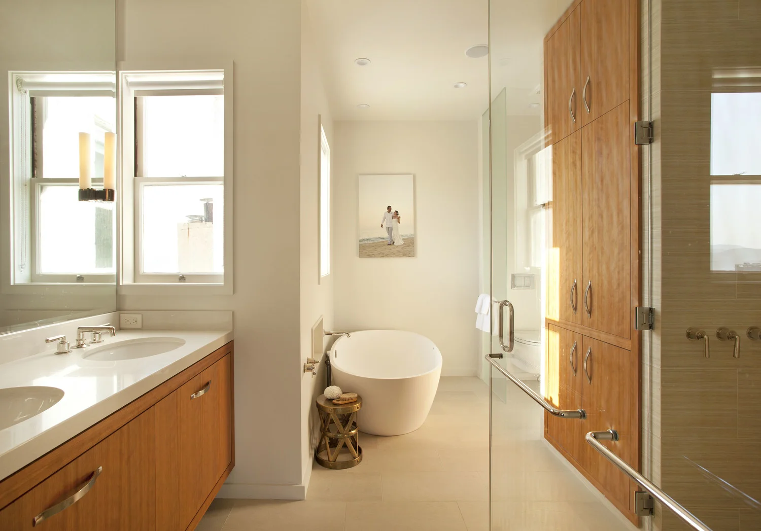 Bathroom renovation in a San Francisco Penthouse designed by Marin interior designer Studio SQUIRE featuring a Double Wood Vanity, Glass Shower, Soaking Tub, and Chrome Fixtures
