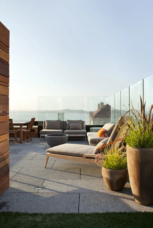 Outdoor Rooftop in a San Francisco Penthouse designed by Marin interior designer Studio SQUIRE featuring Glass Windscreen Panels, Artificial Turf, and Outdoor Seating
