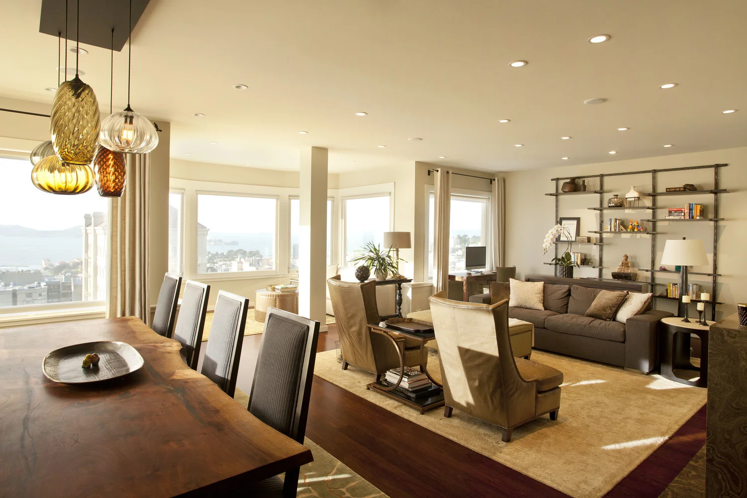 Living Room renovation in a San Francisco Penthouse designed by Marin interior designer Studio SQUIRE featuring a Upholstered Sofa, Accent Chairs, Area Rug, Wall Shelving Unit, Live Edge Dining Table, and Upholstered Dining Chairs