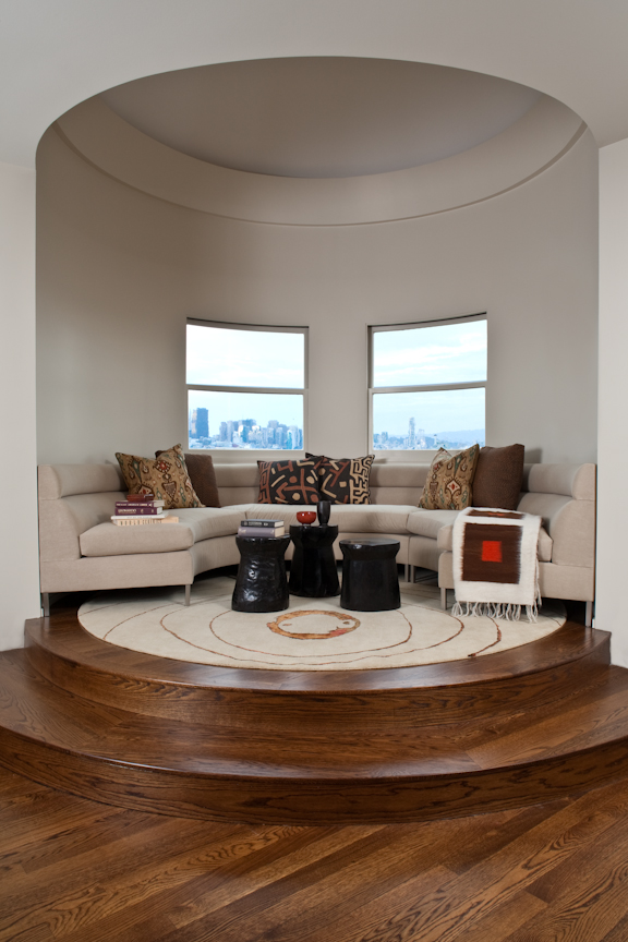 Home renovation in San Francisco designed by Marin interior designer Studio SQUIRE featuring Upholstered Curved Sofa, Round Area Rug, Side Tables, Accent Pillows, and Throw Blanket