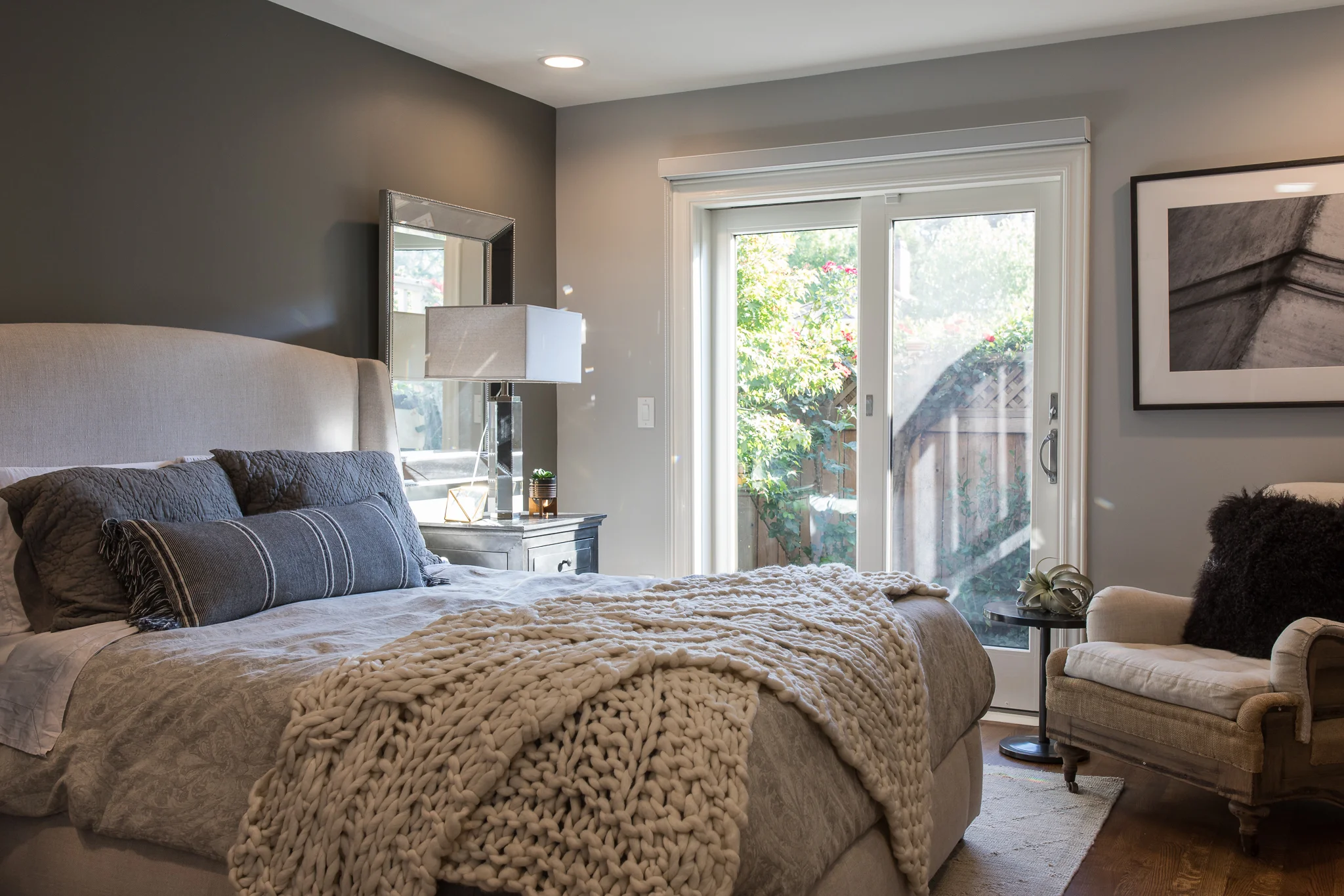 Primary Bedroom in Mill Valley designed by Marin interior designer Studio SQUIRE featuring French Doors, a Upholstered Bed, Side Chair, and Accent Rug