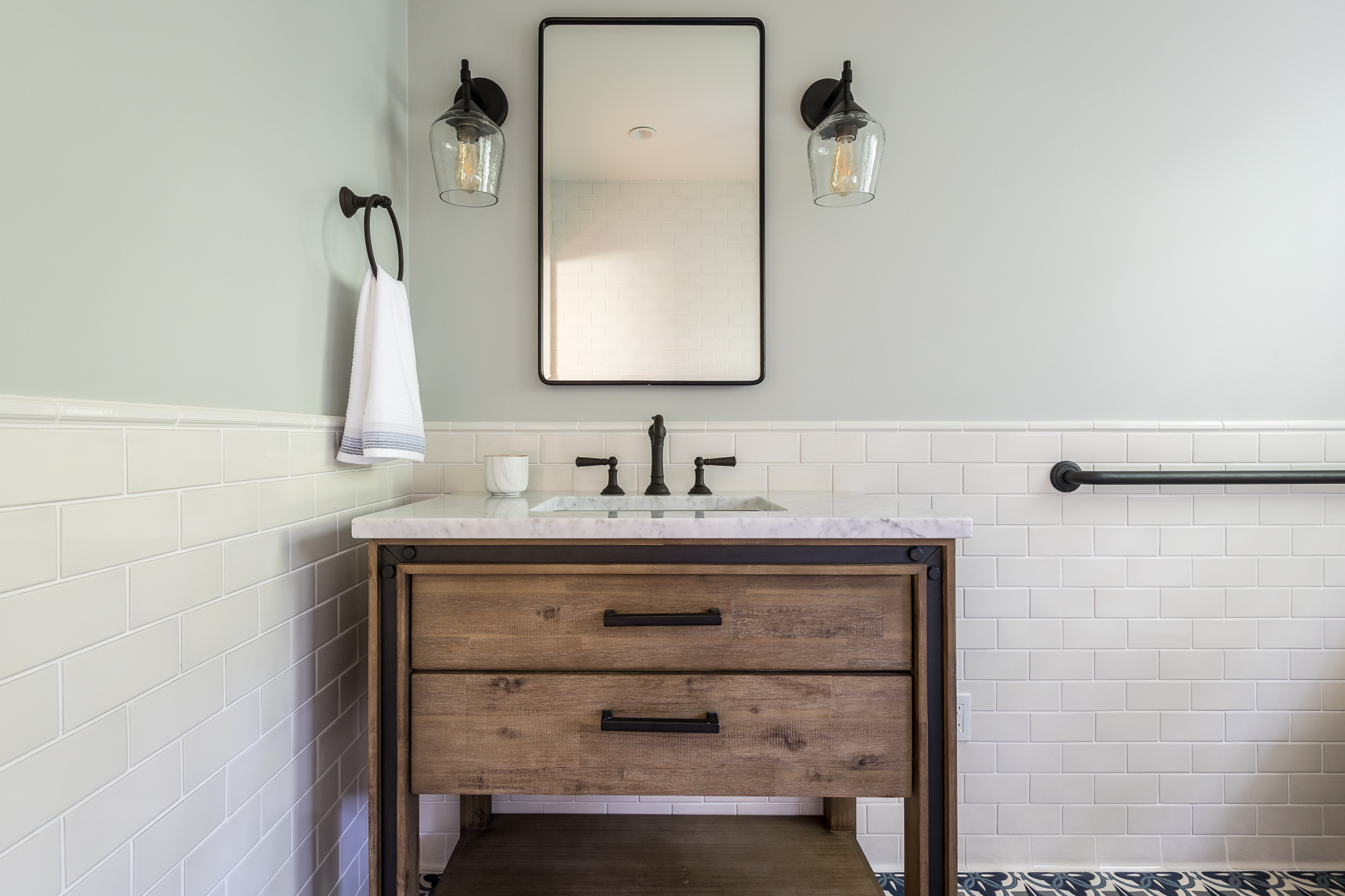 Bathroom renovation in Sausalito designed by Marin interior designer Studio SQUIRE featuring a Wood Vanity, Black Metal Mirror, Black Fixtures, and Subway Tile