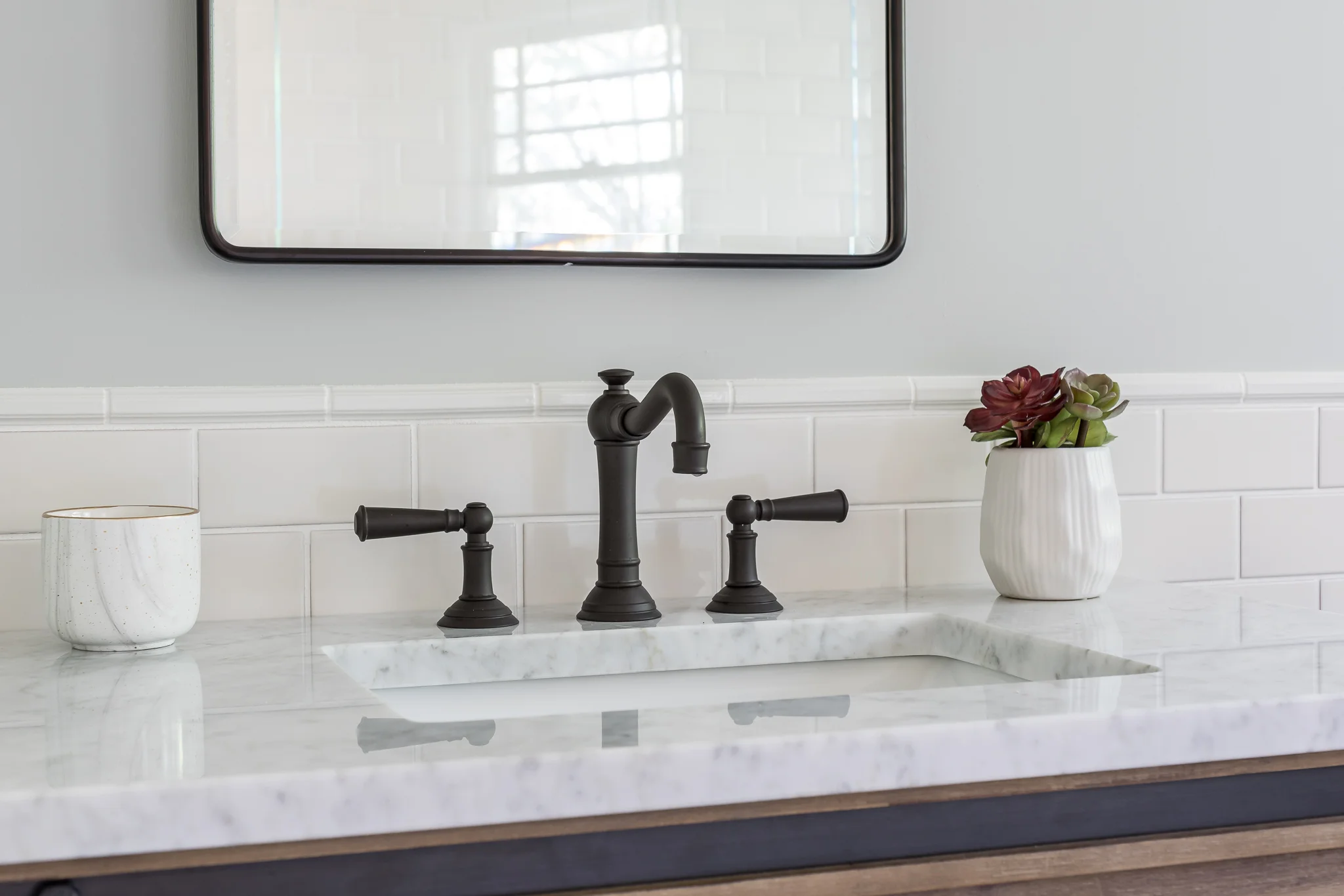 Kitchen renovation in Sausalito designed by Marin interior designer Studio SQUIRE featuring Black Faucet, Marble Countertop, Metal Black Mirror, and Subway Tile