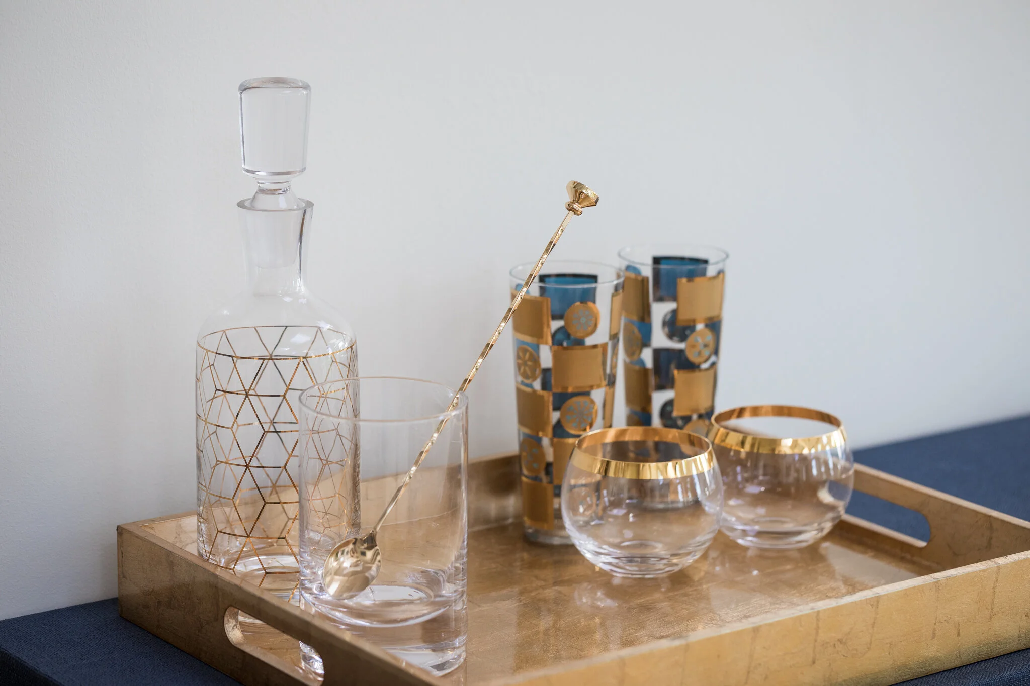 Modern barware in a Mill Valley home designed by Marin interior designer Studio SQUIRE featuring a decanter, glasses, and tray with brass accents.