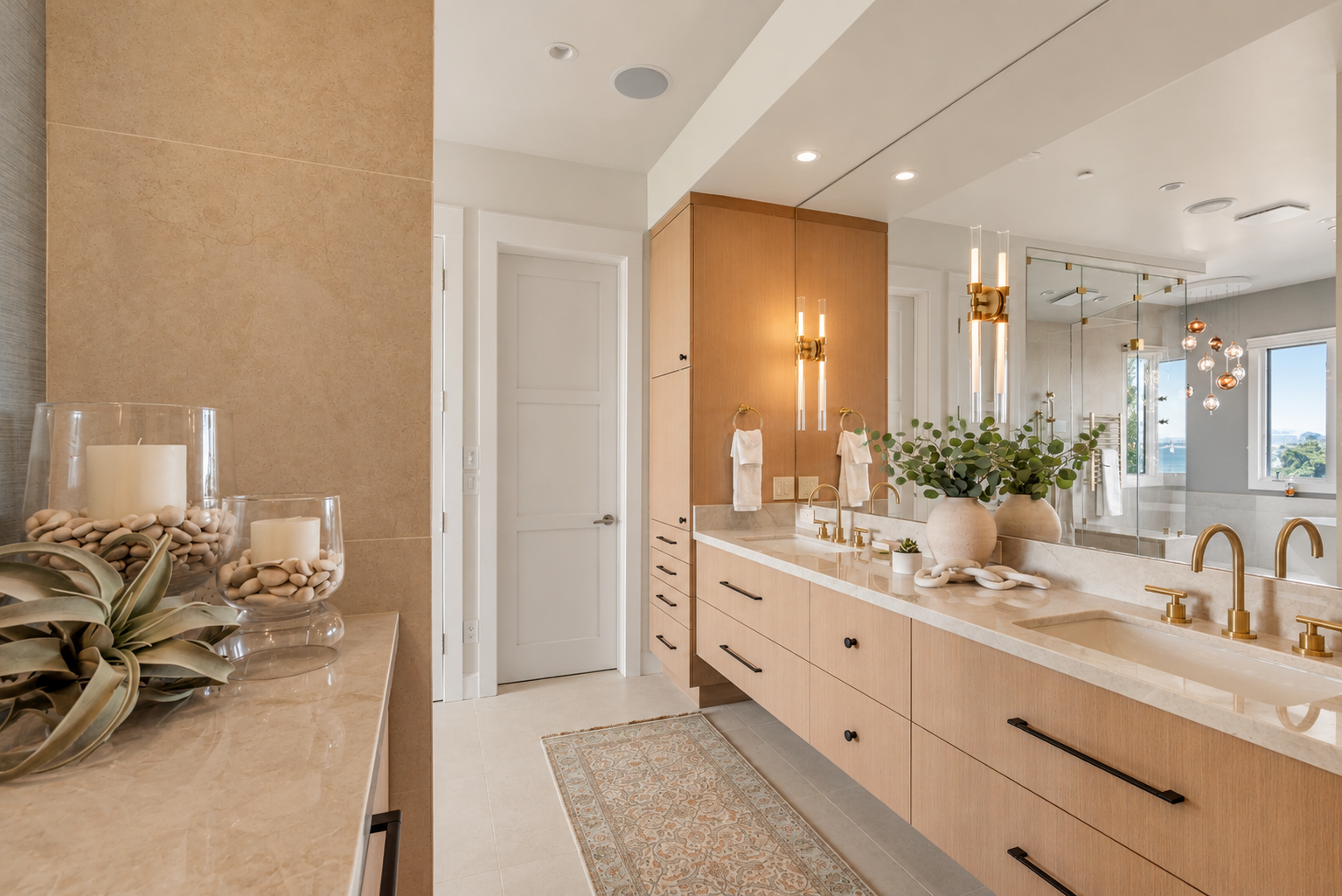 Luxury primary bathroom renovation in Tiburon designed by Marin interior designer Studio SQUIRE featuring white oak custom casework, quartzite countertops, satin brass plumbing fixtures, and oil rubbed bronze cabinet hardware.