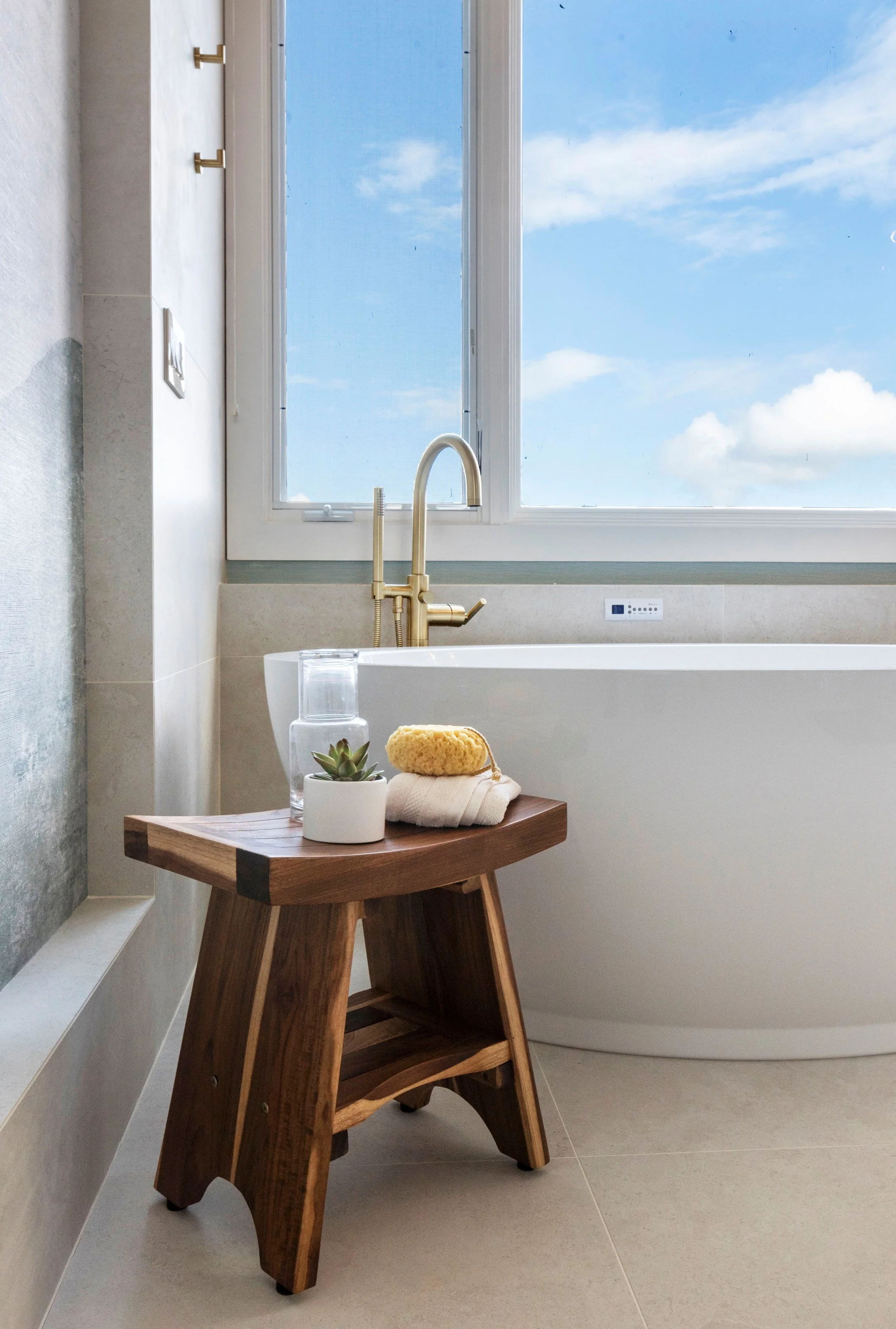 Luxury primary bathroom renovation in Tiburon designed by Marin interior designer Studio SQUIRE featuring a coastal wallpaper mural, freestanding soaking tub, and views of the San Francisco Bay.