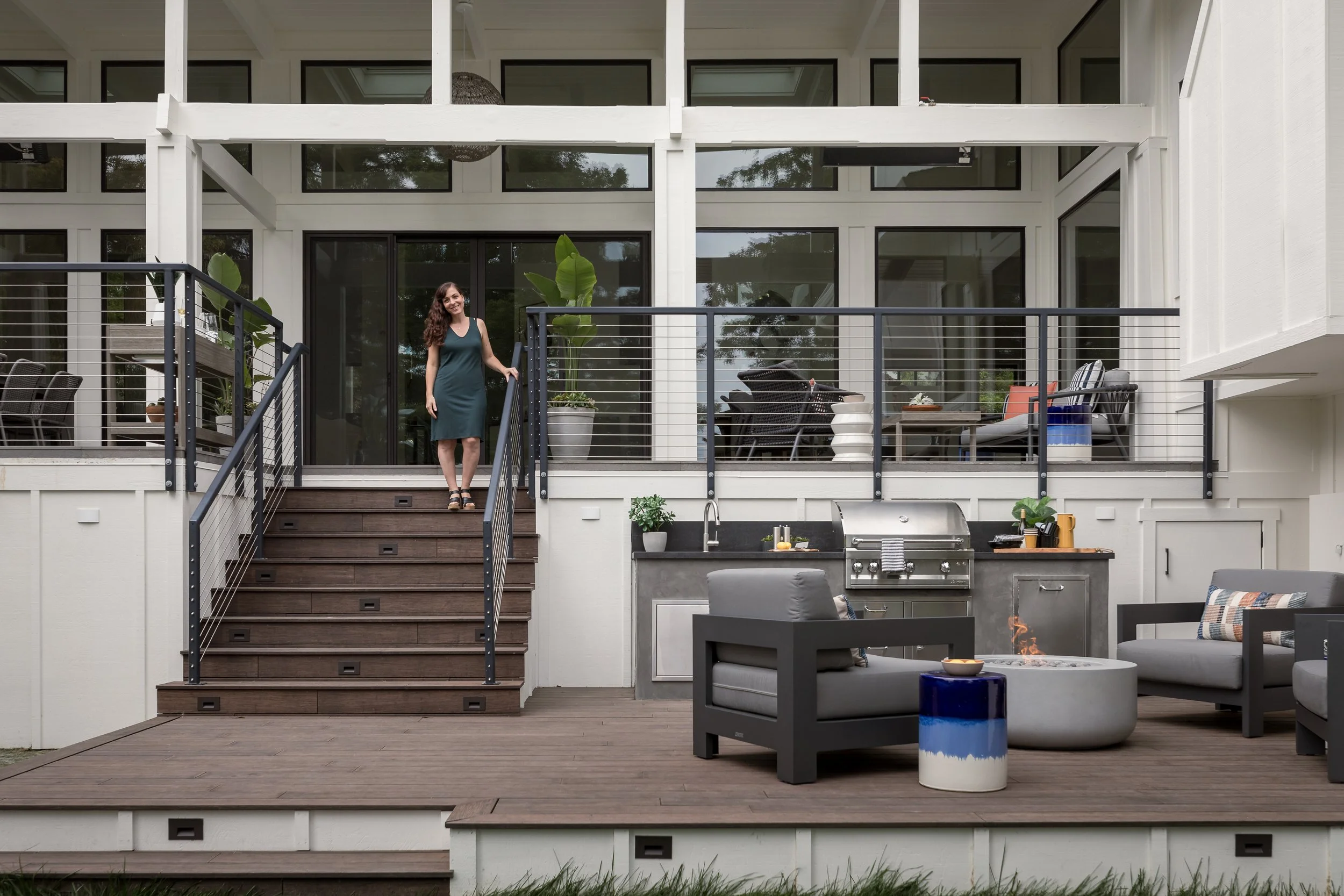 Outdoor deck renovation in Mill Valley designed by Marin interior designer Studio SQUIRE featuring a custom outdoor kitchen, fire pit, lounge seating, and modern cable railing.