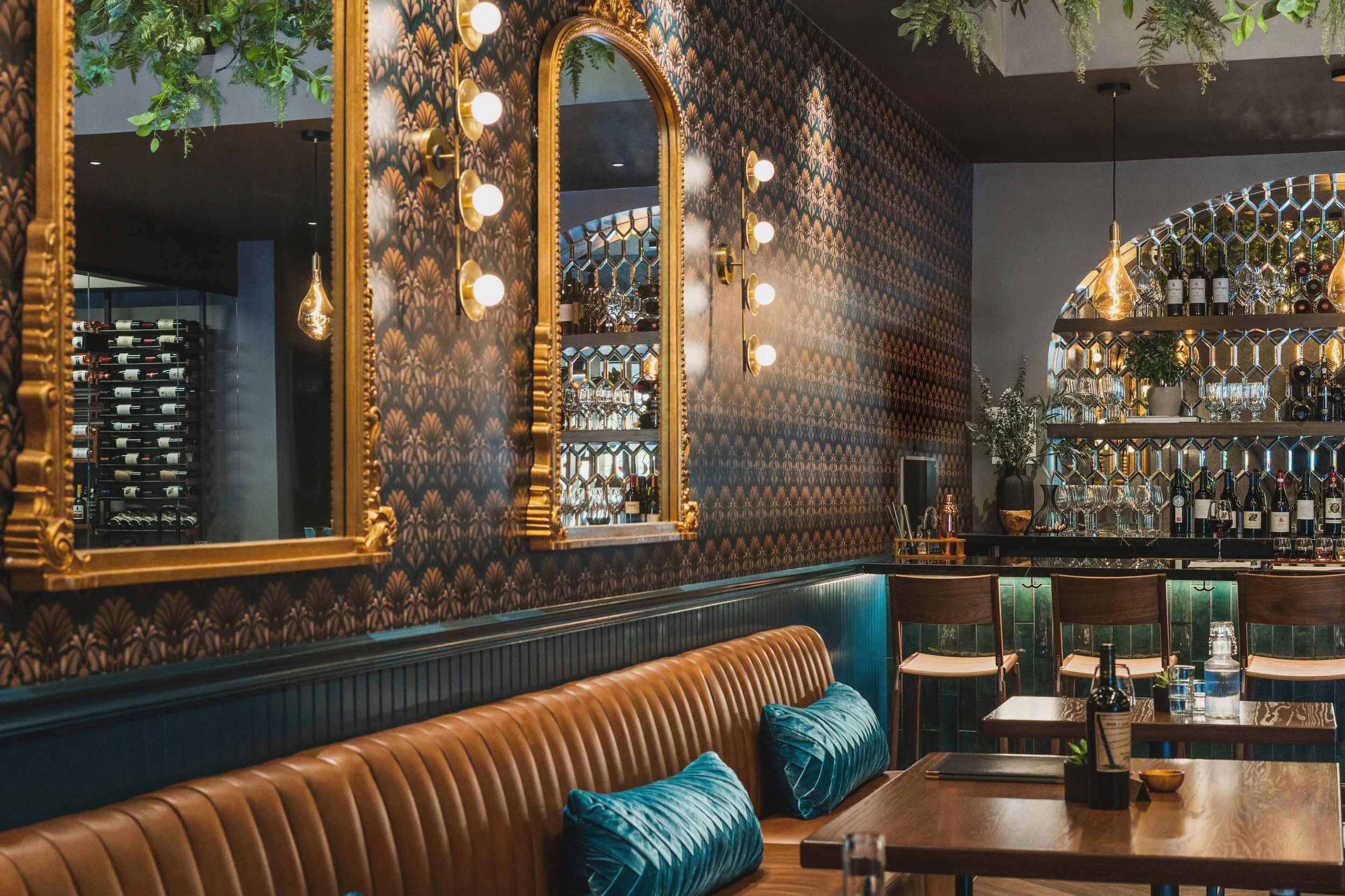 Wine bar renovation in Tiburon designed by Marin interior designer Studio SQUIRE featuring mirror backsplash tile, wallpaper, brass fixtures, wood shelving, and wine storage