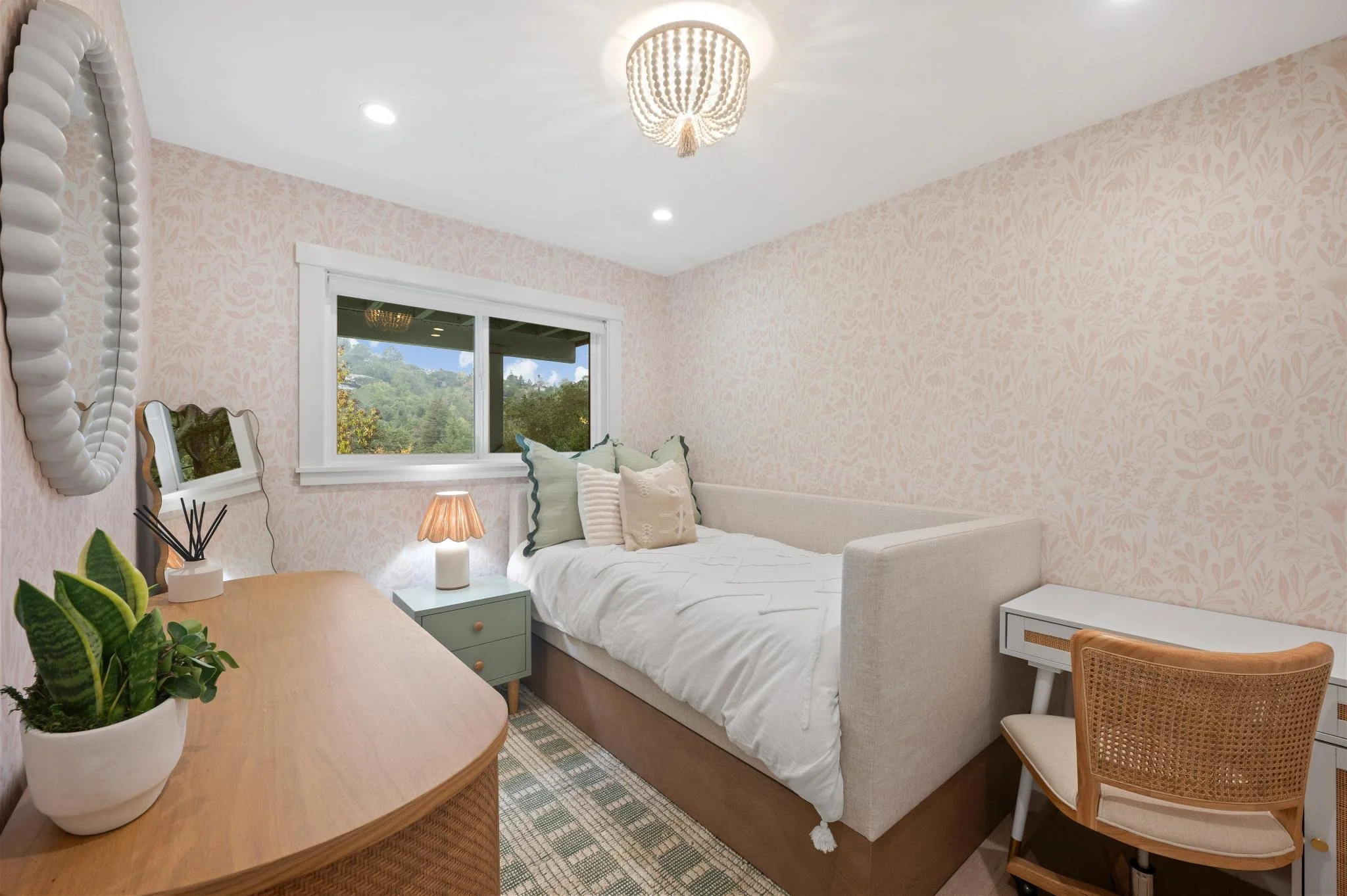 Kids Bedroom renovation in San Anselmo designed by Marin interior designer Studio SQUIRE featuring Floral Wallpaper, Wood Dresser, Rattan Chair, and Day Bed..