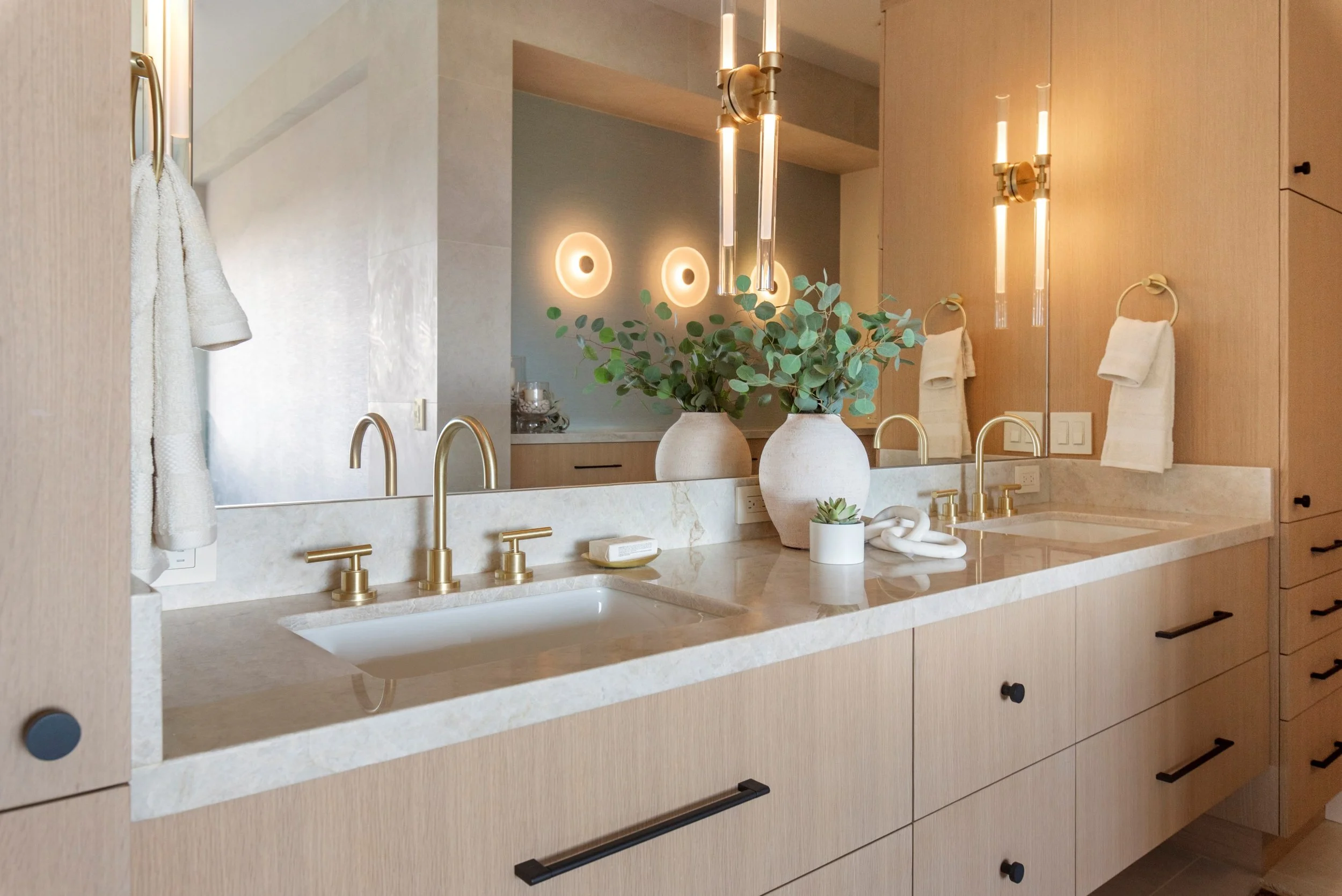 Luxury primary bathroom renovation in Tiburon designed by Marin interior designer Studio SQUIRE featuring white oak custom casework, quartzite countertops, satin brass plumbing fixtures, and oil rubbed bronze cabinet hardware.