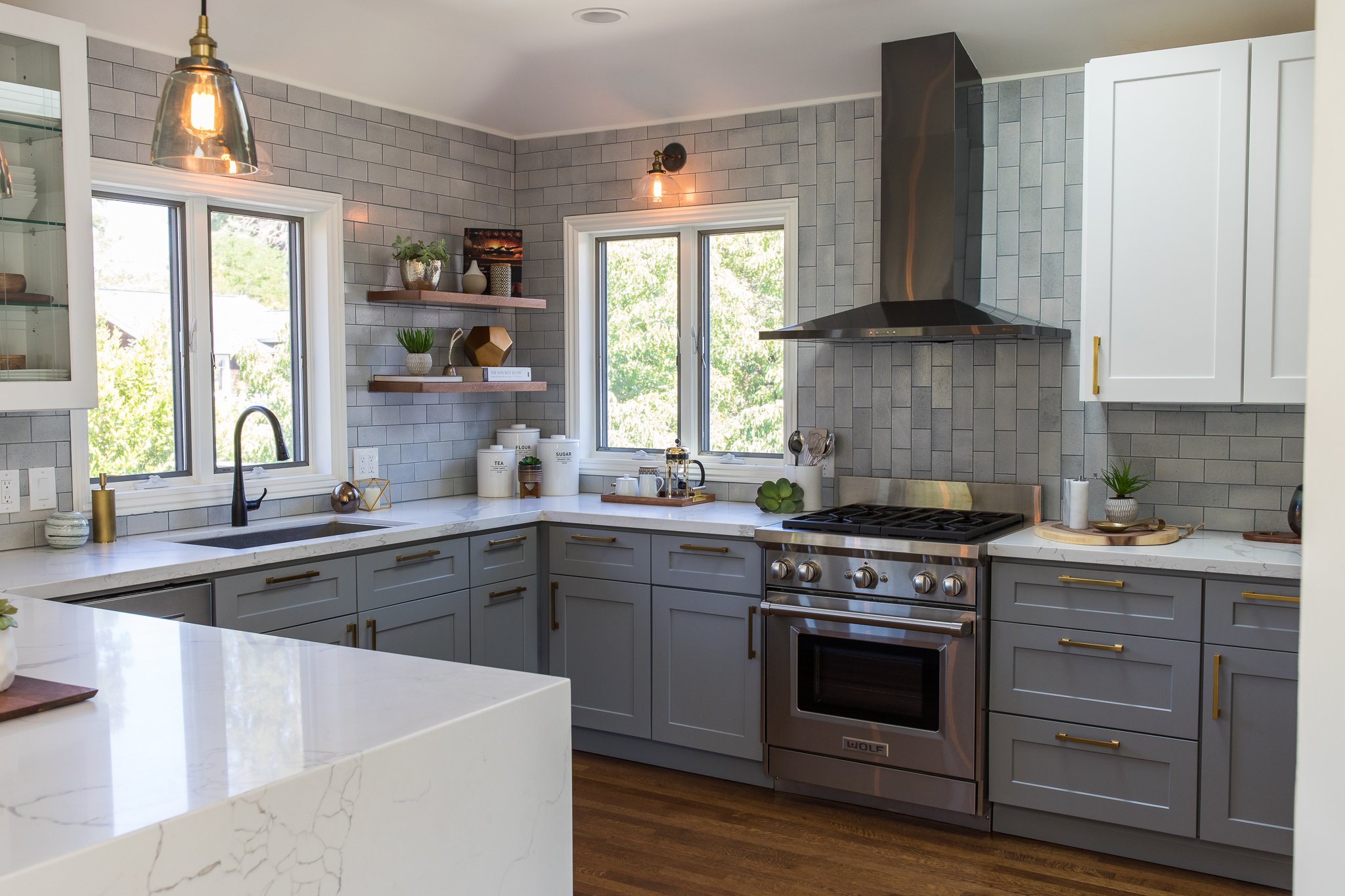 Kitchen renovation in Mill Valley designed by Marin interior designer Studio SQUIRE featuring marble countertops, wood shelving, brass hardware, and oil rubbed bronze fixtures