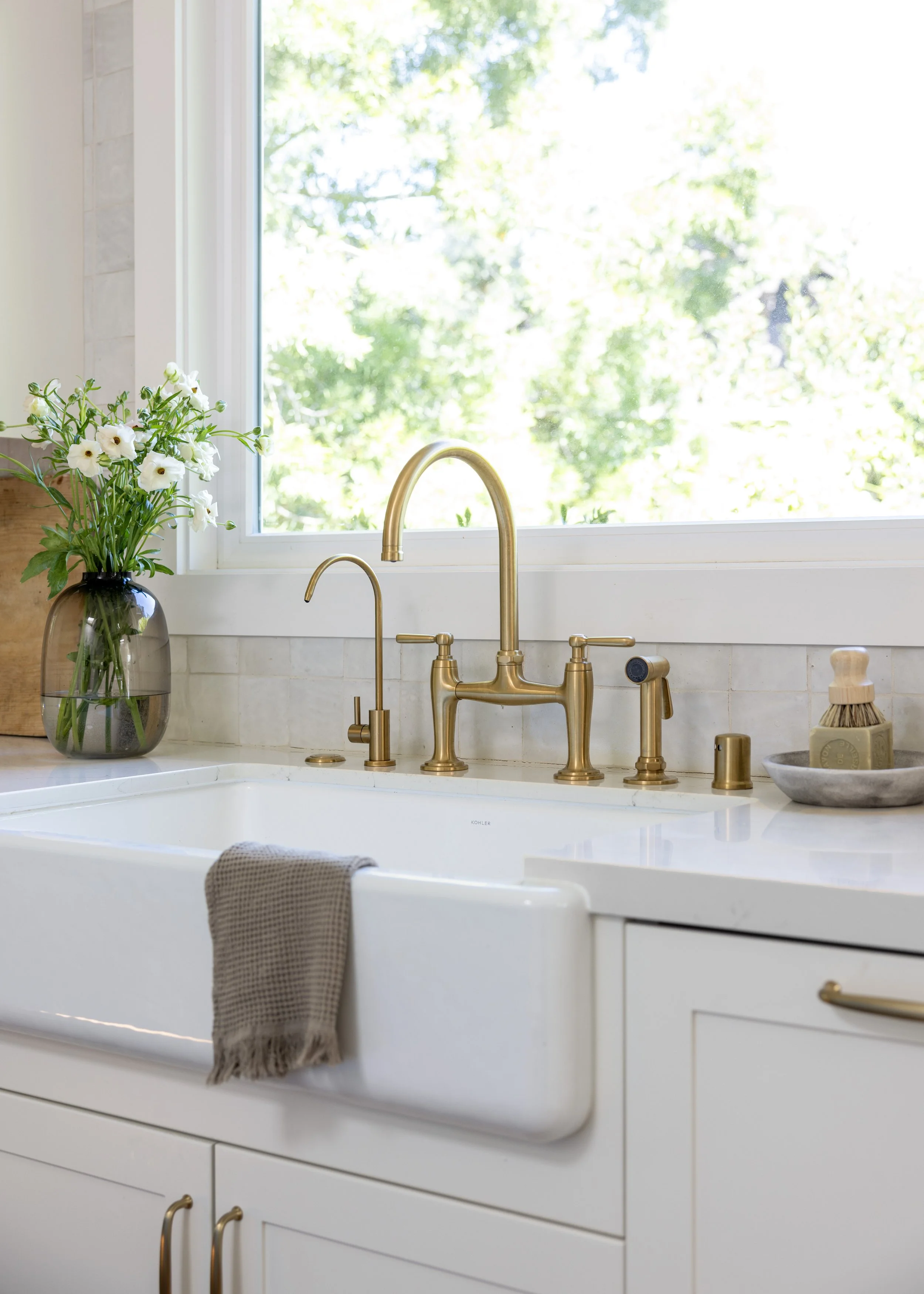 Kitchen renovation in Kentfield designed by Marin interior designer Studio SQUIRE featuring Brass Fixtures, Undermount Farmhouse Sink, Ceramic Tile Backsplash, and Quartz Countertop