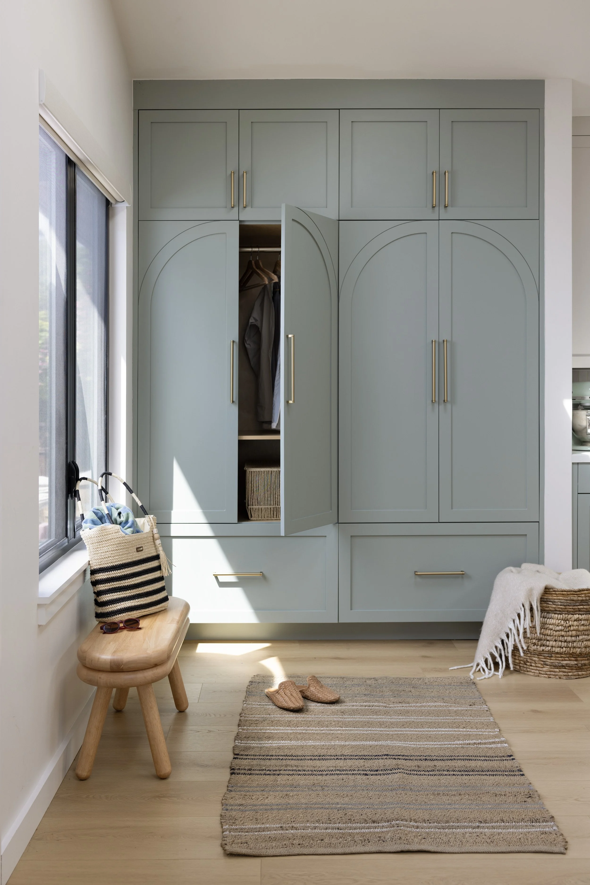 Entry renovation in Mill Valley designed by Marin interior designer Studio SQUIRE featuring Sage Green Cabinetry and Brass Handles