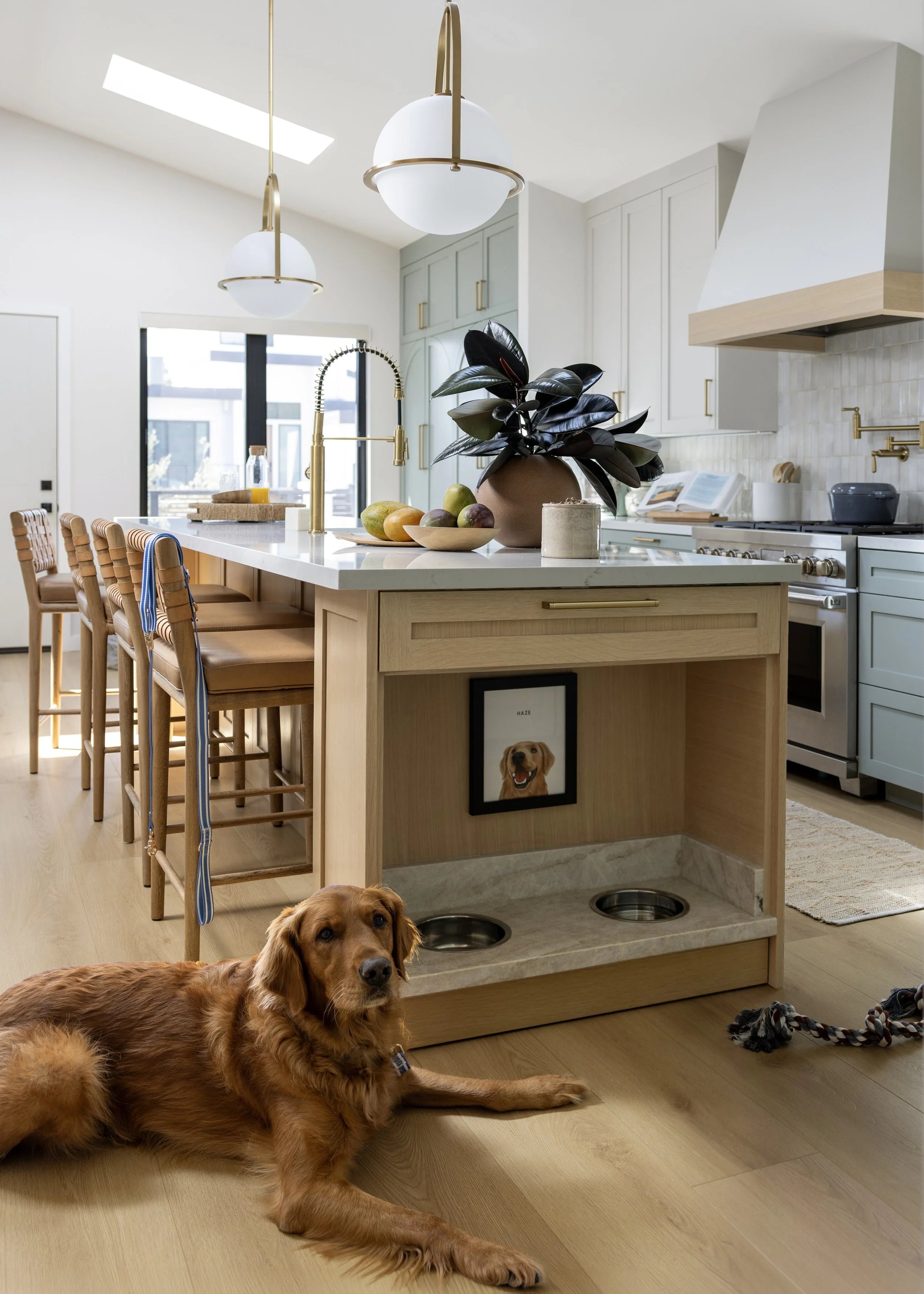 Kitchen renovation in Mill Valley designed by Marin interior designer Studio SQUIRE featuring Brass Pendants, Quartz Countertops, Marazzi Tile, and Custom Dog Feed Station