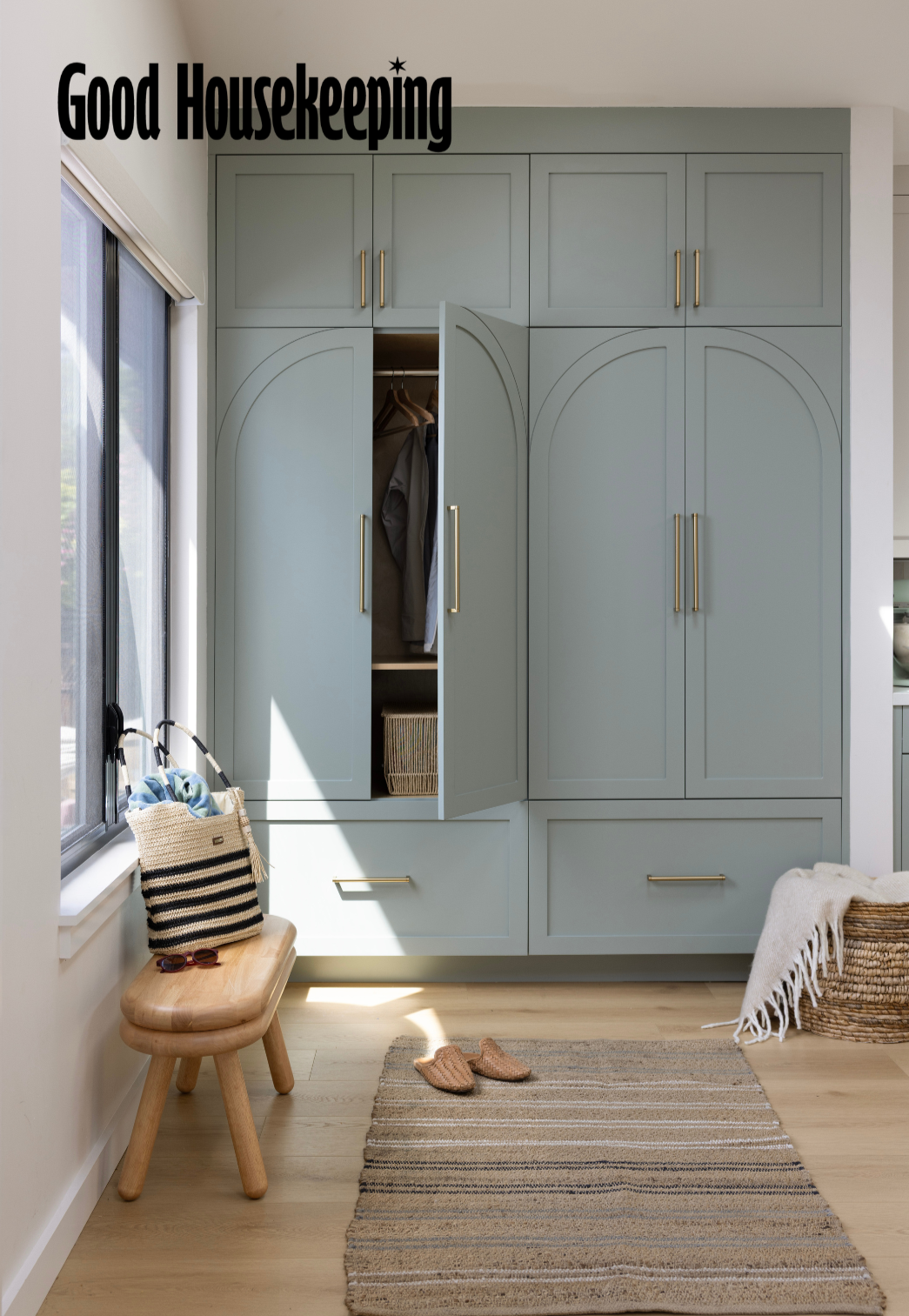 Entry renovation in Mill Valley designed by Marin interior designer Studio SQUIRE featuring olive green cabinetry, oak wood flooring, brass hardware, and bench